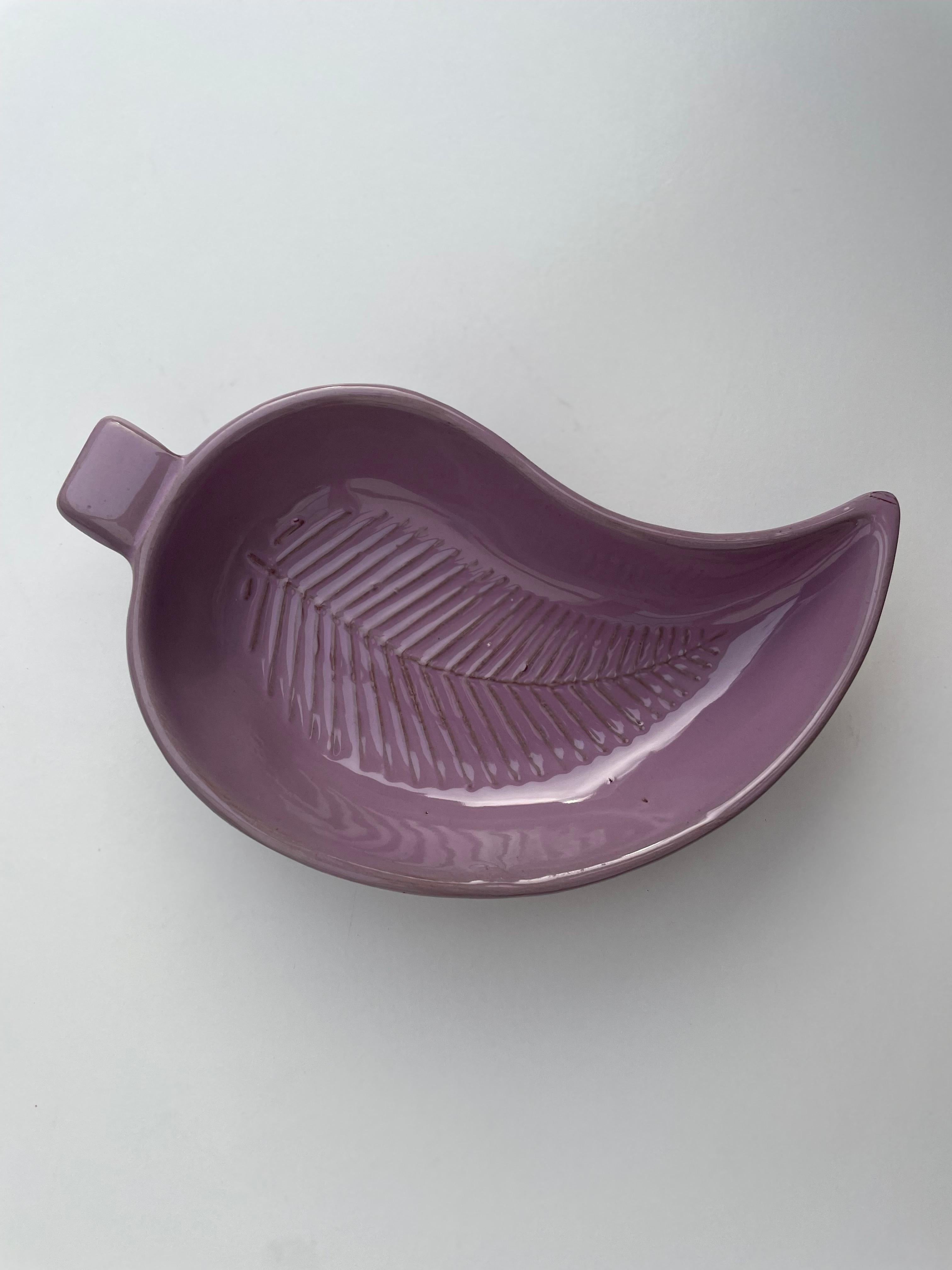 Handmade leaf shaped vide poche. Thick lilac glaze over lined relief pattern. Small square shaped handle on asymmetrical bowl form with pointy end. Numbered under base. Great vintage condition. 
Scandinavia, 1960s. 