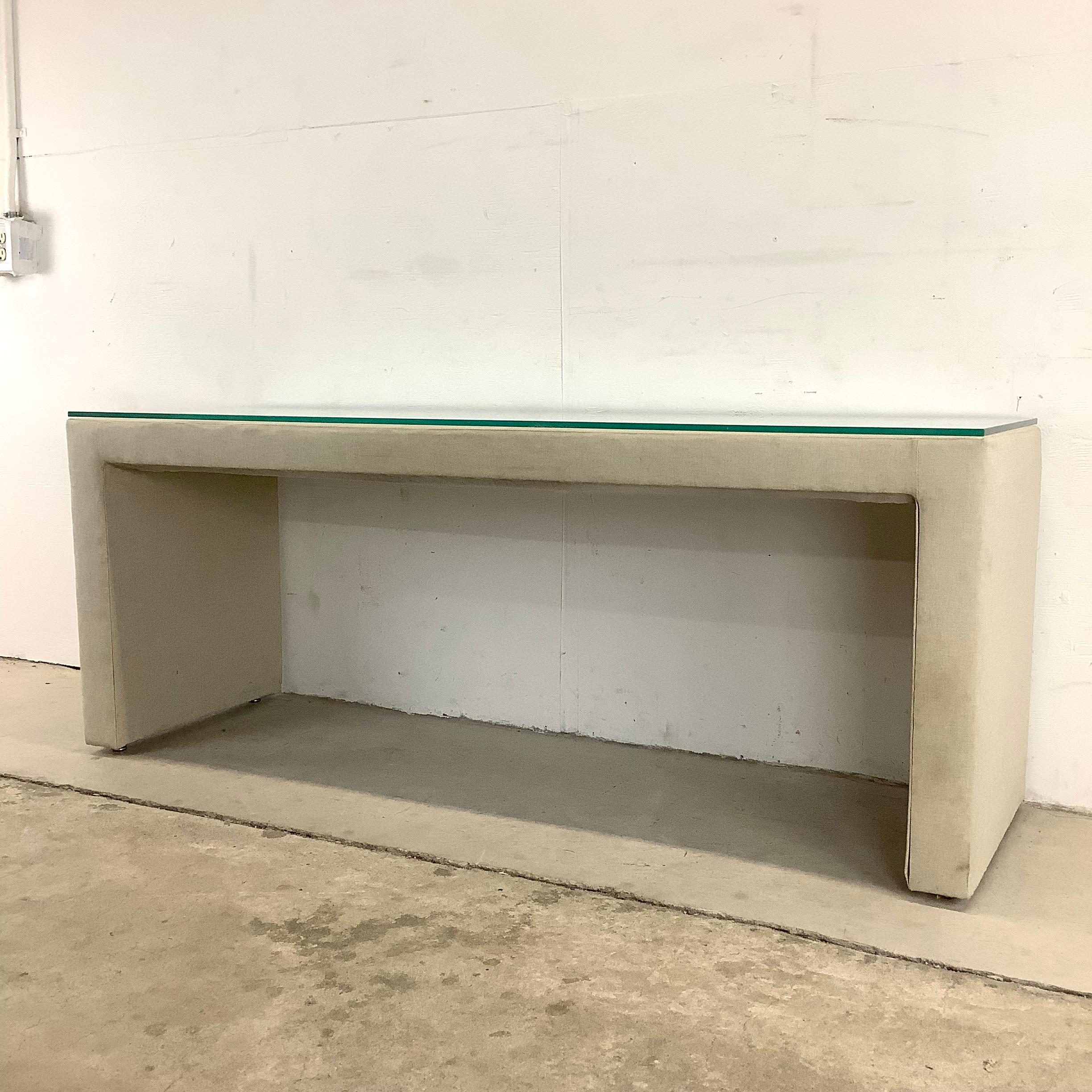 This impressive modern linen console table with removable glass top makes a stylish yet unimposing occasional table for any setting. Unique height and wide sturdy construction make it excellent for display in every room from home entryway to