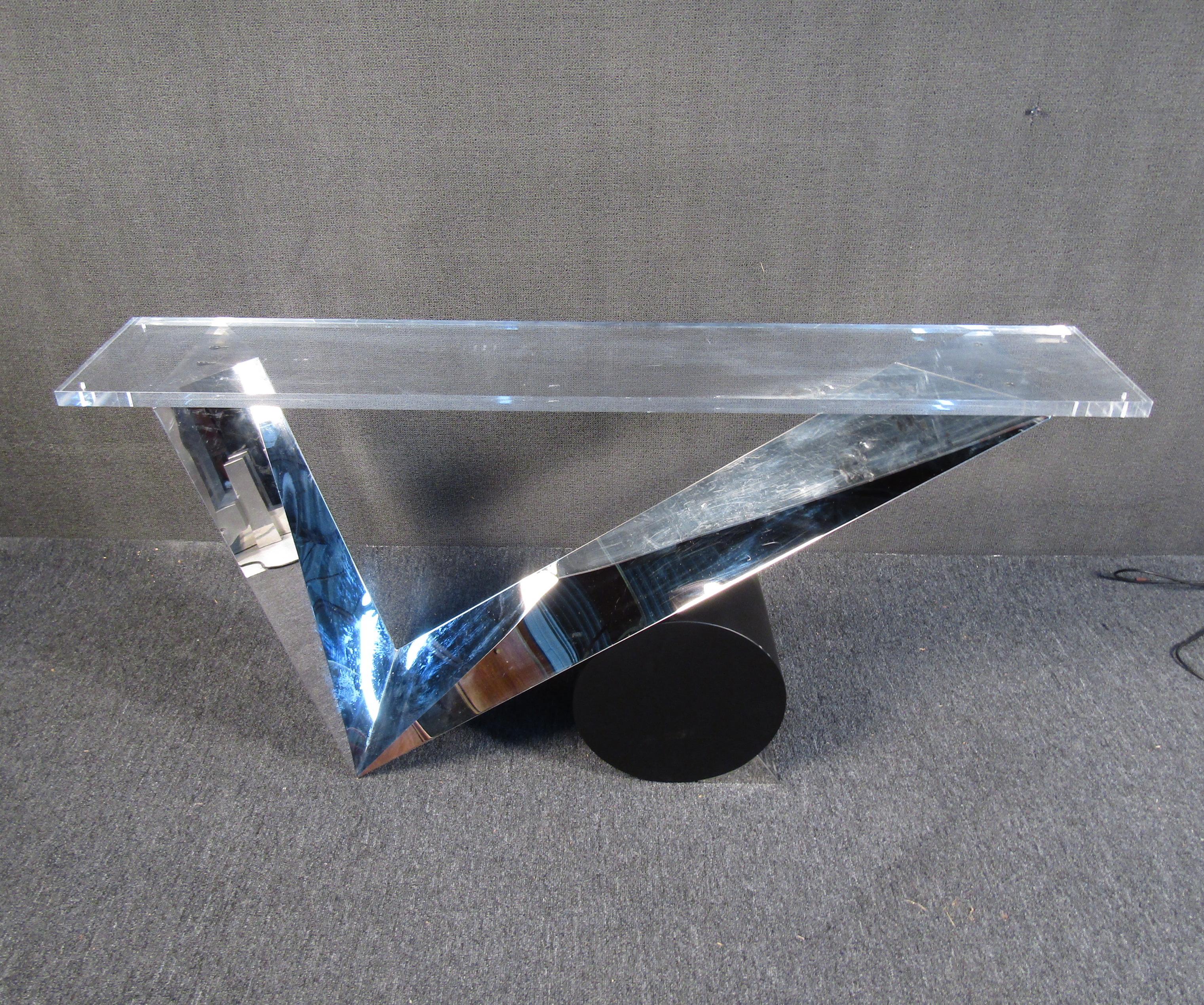 A highly unusual console table that is sure to wow with its geometric forms and unique construction. A Lucite top sits atop a base of glass mirror and metal for a striking visual effect. Please confirm item location with seller (NY or NJ).