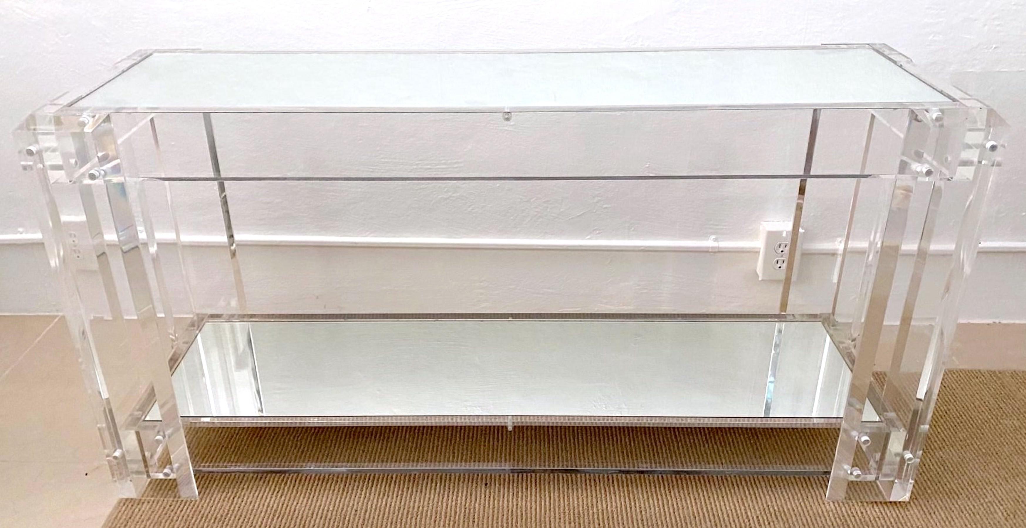 Modern lucite Chrome Mounted Two-Tier Mirrored Console Table 
USA, 1990s


A substantial table beautifully made in the manner of Charles-Hollis Jones, with thick and clear lucite. Of rectangular form with inset mirror top joined by inset chrome