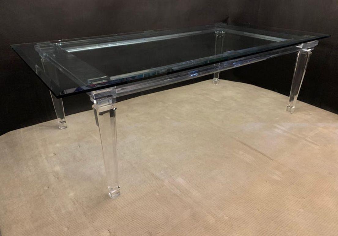 This striking lucite dining table, crafted in the USA during the early 2000s, epitomizes modern sophistication and contemporary design. The table showcases the sleek and transparent beauty of lucite, a durable and versatile material known for its