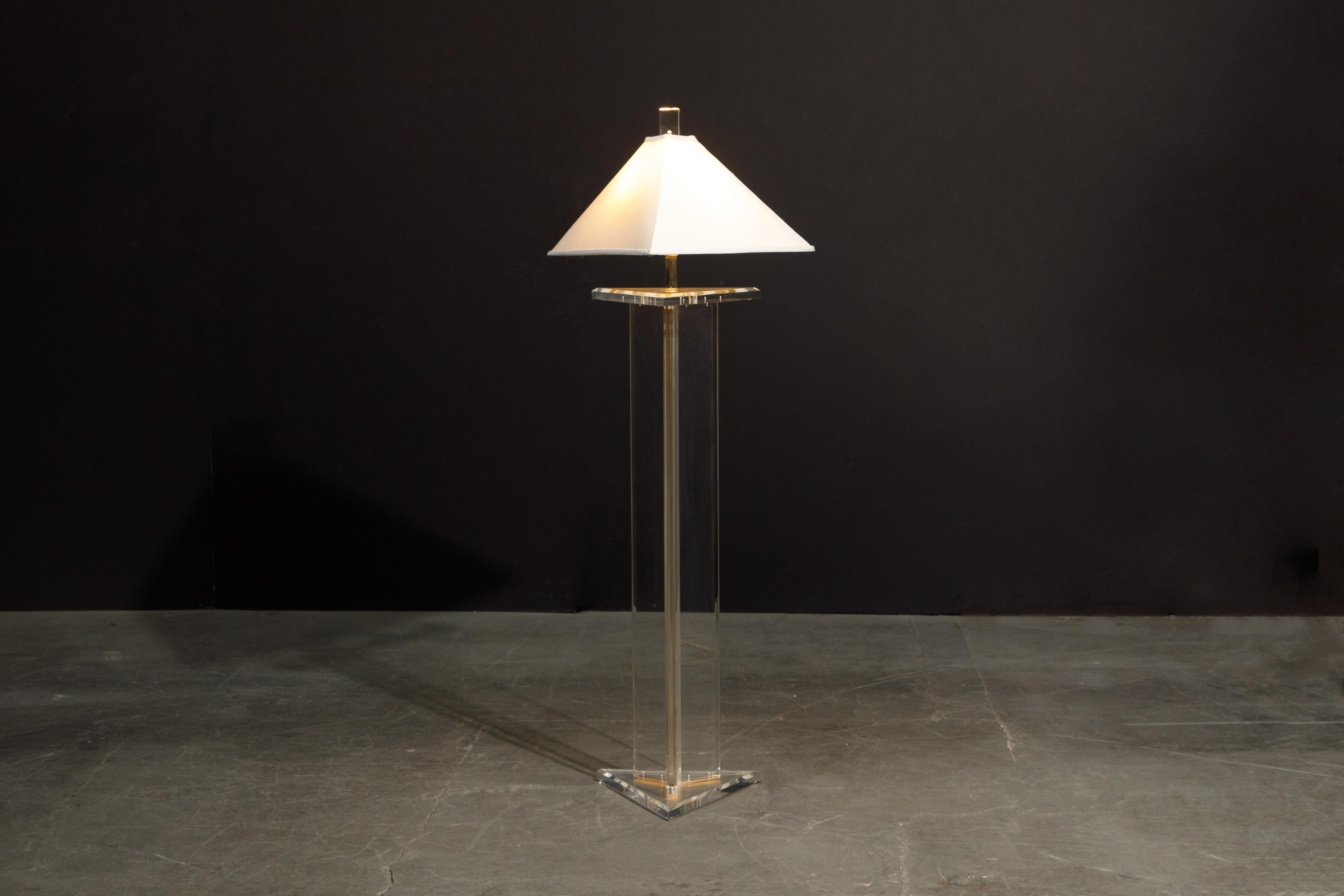 This beautiful lucite floor lamp by Marlee, circa 1970s, is signed and features a triangular shaped profile with matching lucite finial which lightly glows when the lamp is on. Comes with a simple pyramid shaped lampshade and wired for US outlets