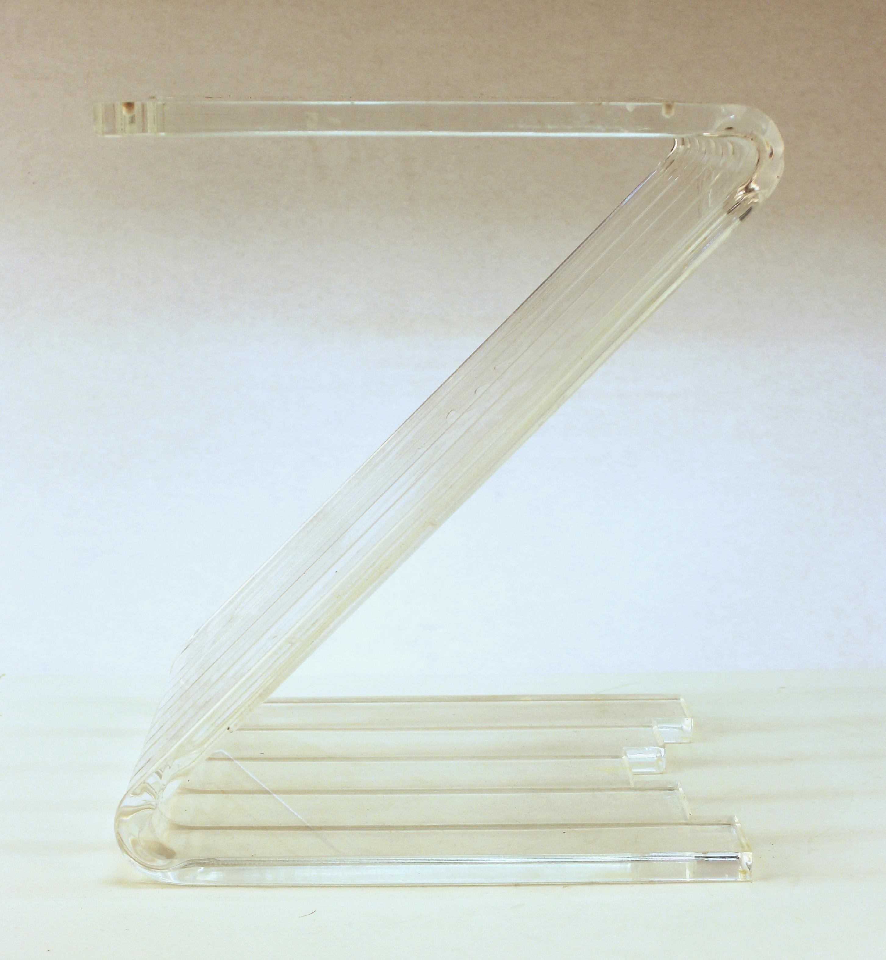 Modern Lucite side table designed in a Z shape, made in the United States during the 1970s. The piece is in good vintage condition and has age-appropriate scratches on the top and bottom of the Lucite.