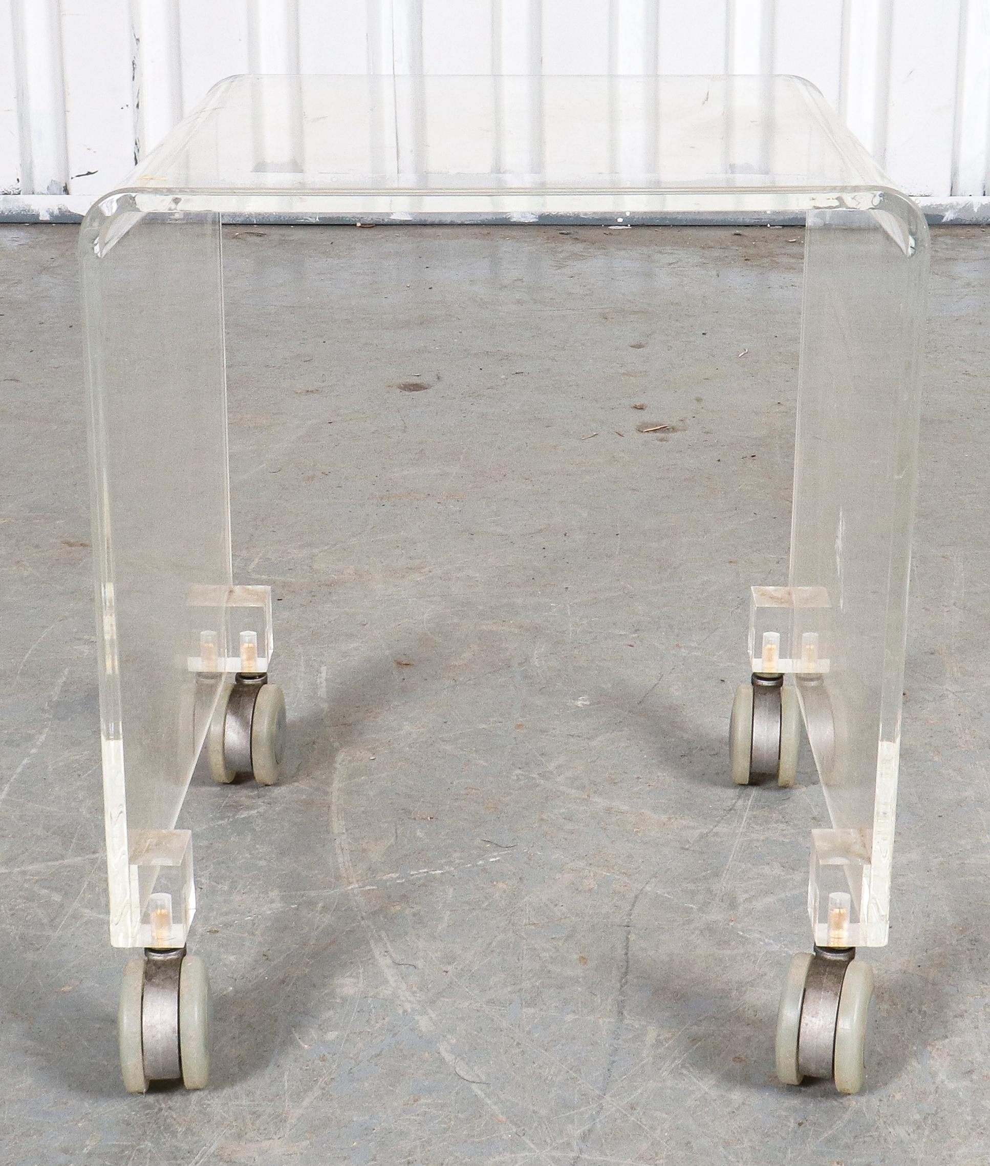 Modern Lucite waterfall side table on casters. Measures: 16.5