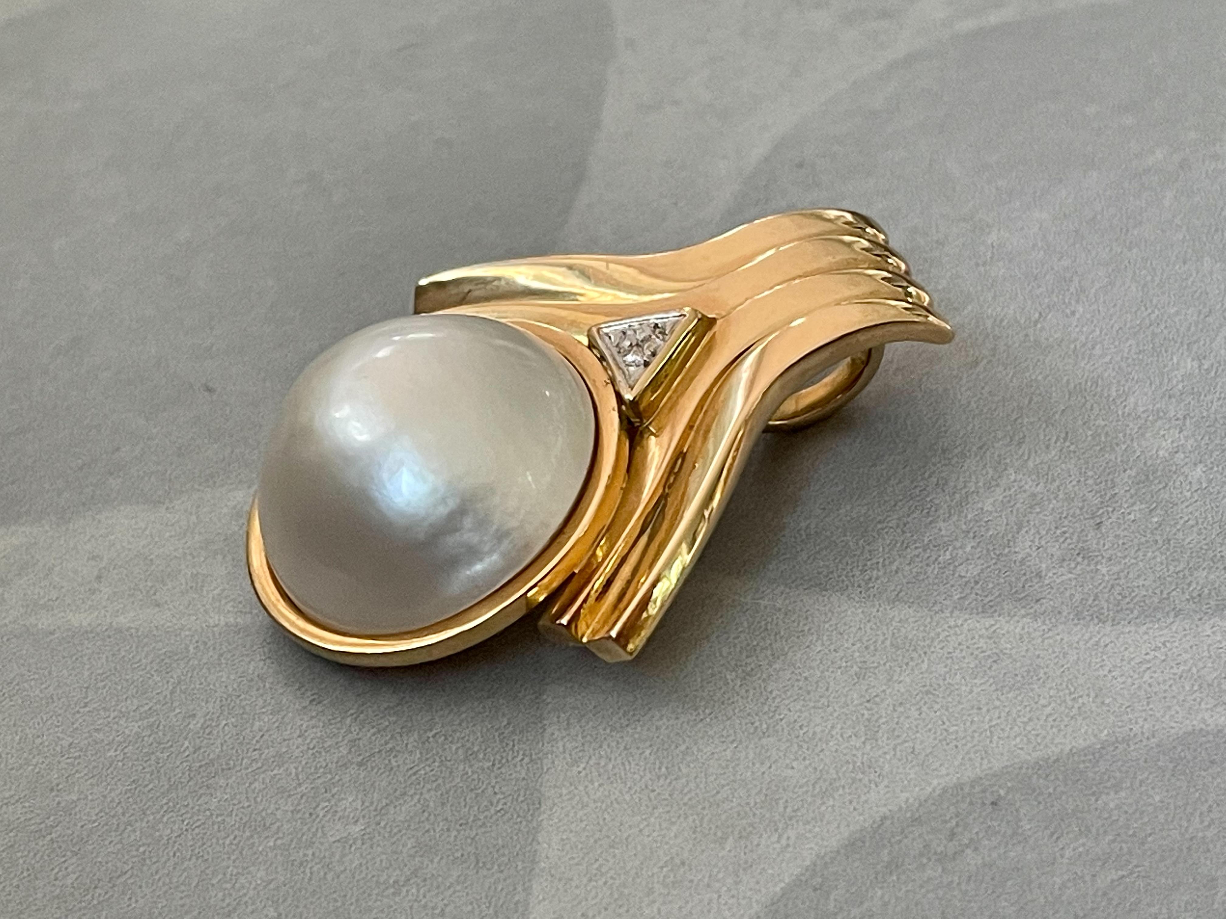 This modern enhancer-style pendant features a 20mm Mabe Pearl set in 14 karat yellow Gold.

Weight: 17.8 grams

Size:  33 x 41mm (1-1/2
