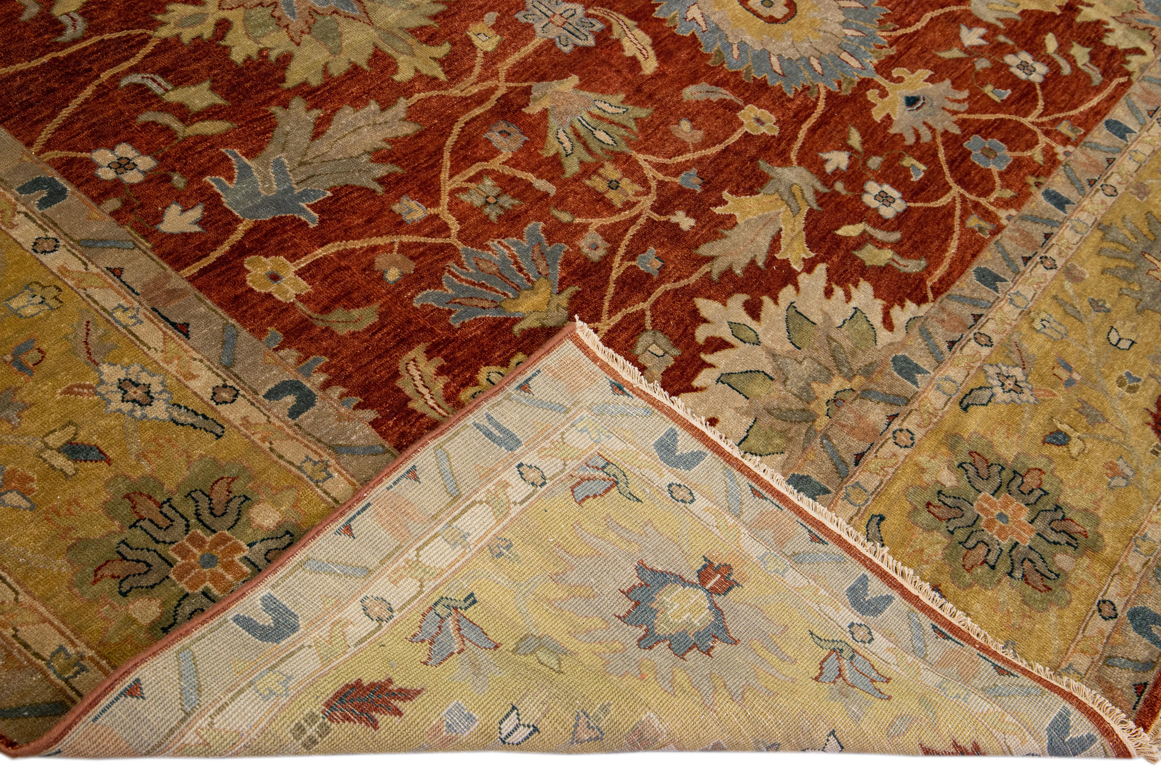 Beautiful hand-knotted Modern Mahal wool rug with the terracotta field. This Persian rug has a tan frame and multicolor accents featuring a traditional floral pattern design. 

This rug measures 12'1