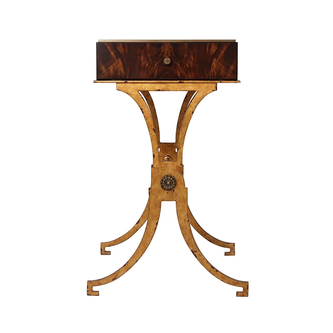 A modern flame mahogany veneered lamp table, the rectangular top with an inset brass edge, with two opposing end drawers, on antiqued gilt iron x end supports joined by a stretcher.

Dimensions: 23.5