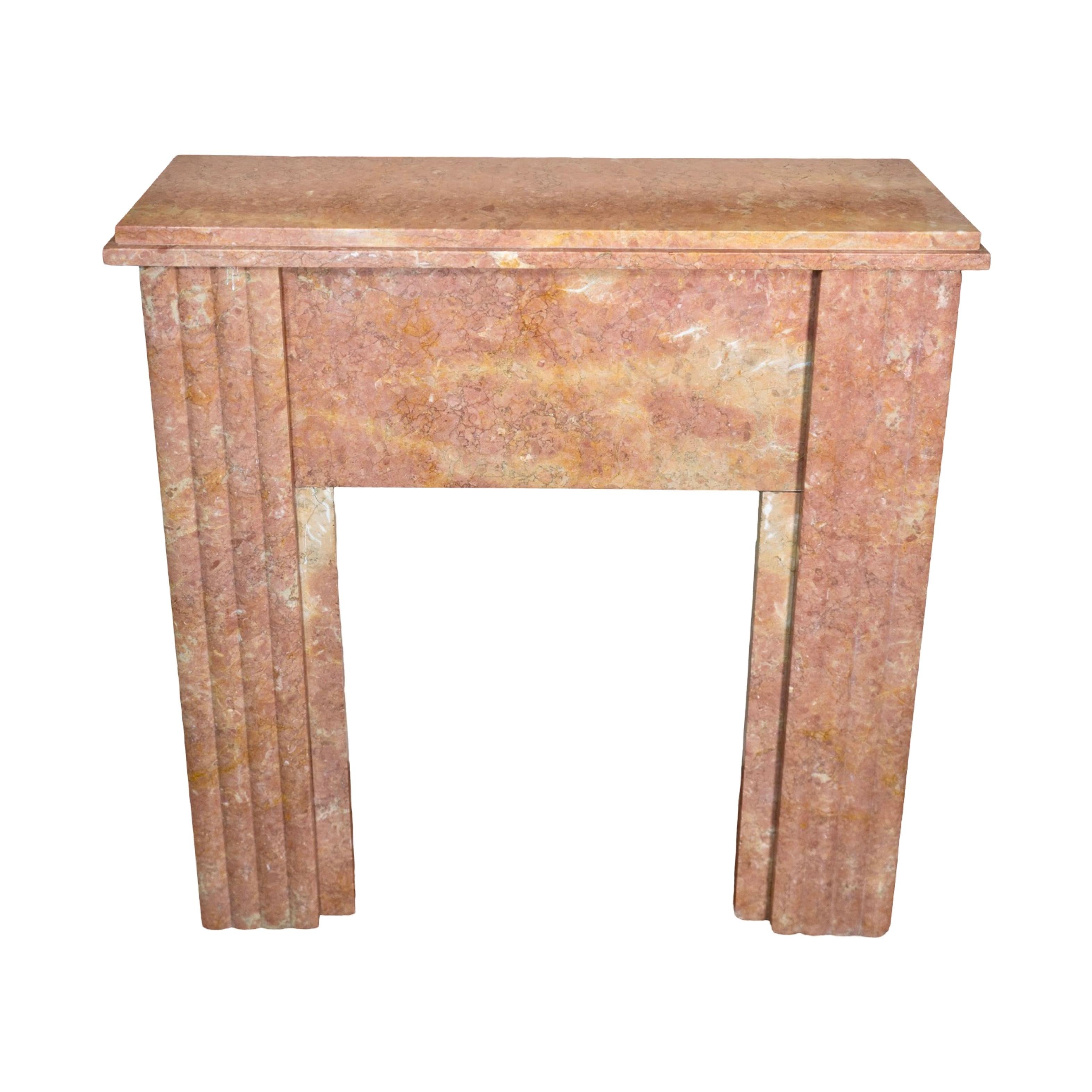 Elevate your living room or den with our French Orange Varois Marble Mantel. Crafted from elegant marble with intricate fluted carved supports, this timeless masterpiece exudes modern sophistication. Originally designed in 1925, this small baby size