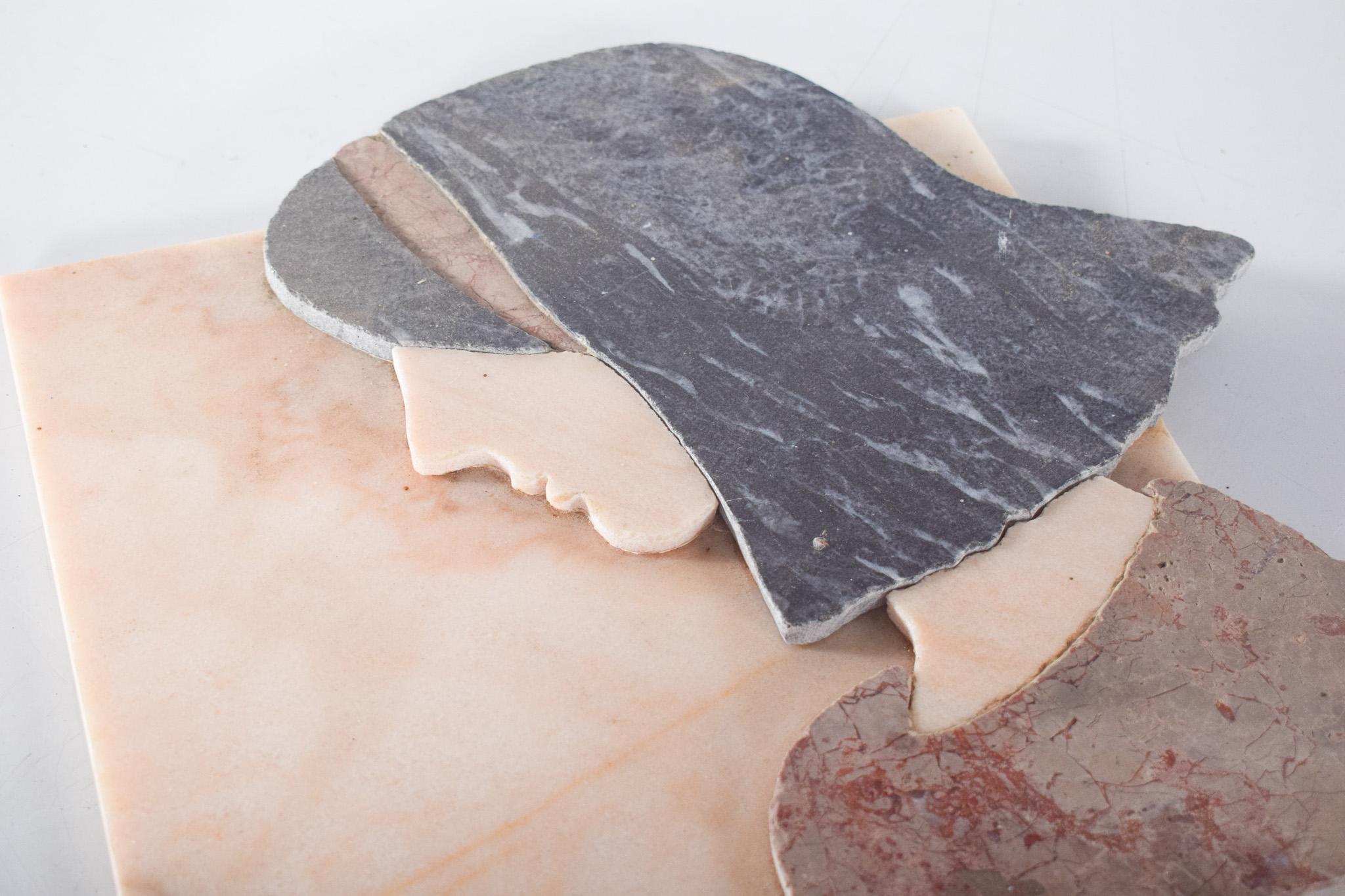 Marble sculpture by Sylvia Westfallen. This sculpture represents the profile of a woman with black hair, seen from the side. The composition is made with different types of marble, carefully polished, cut and applied to a square base in a light