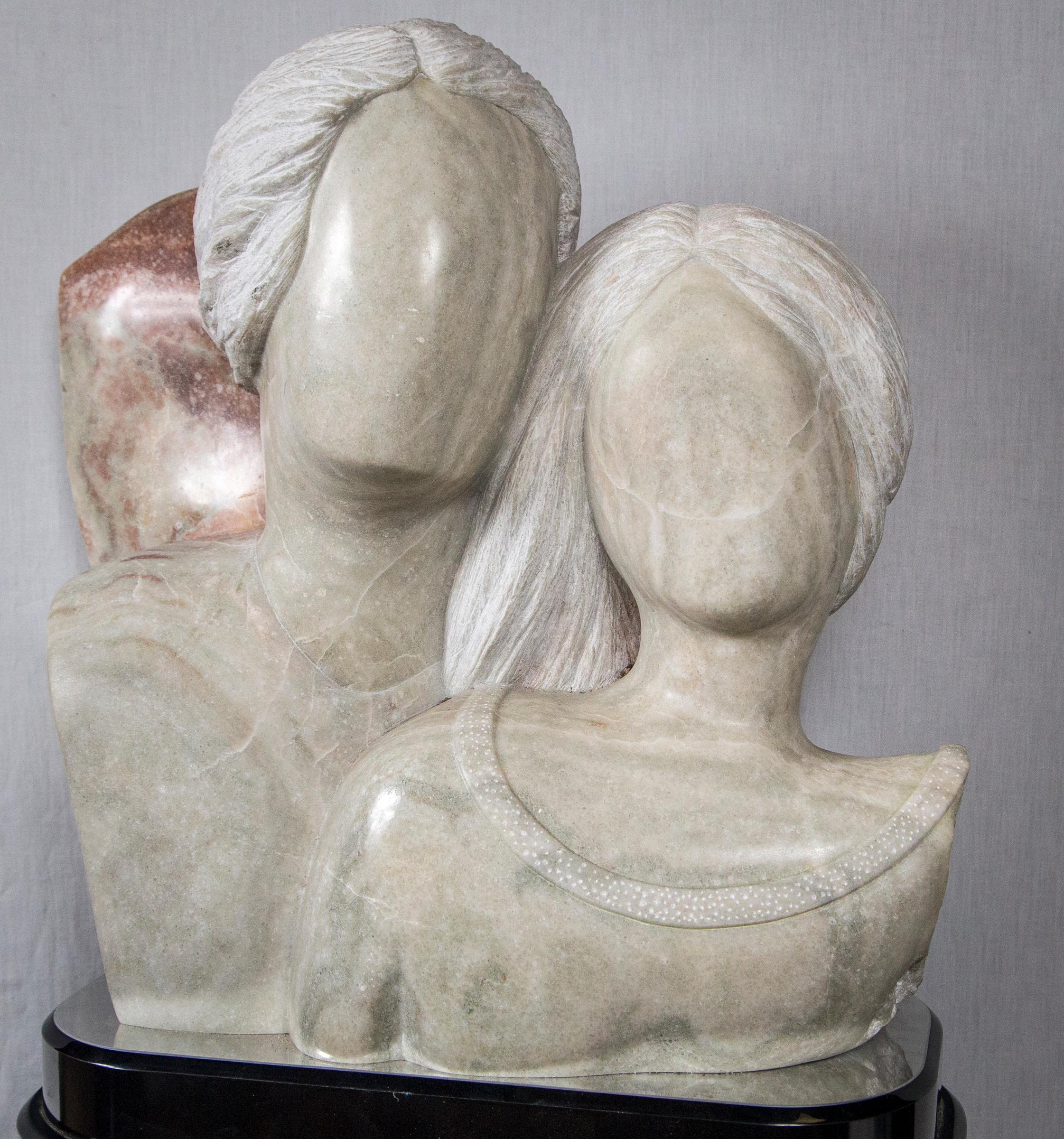 Carved of marble with polished faces and no detail. Roughhewn back.
Mirrored top below them on a swivel top of the custom made pedestal.
The pedestal is an elongated oval, measuring 19.25 wide, 42.5 tall and 10.5 deep. The sculpture itself is