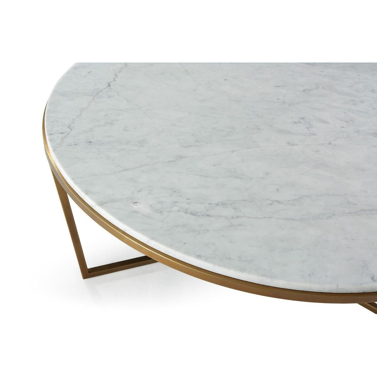 A modern marble top cocktail table with a stepped edge. The circular Bianco Carrara marble top sits on a brushed brass finish base. 

Dimensions: 47.25
