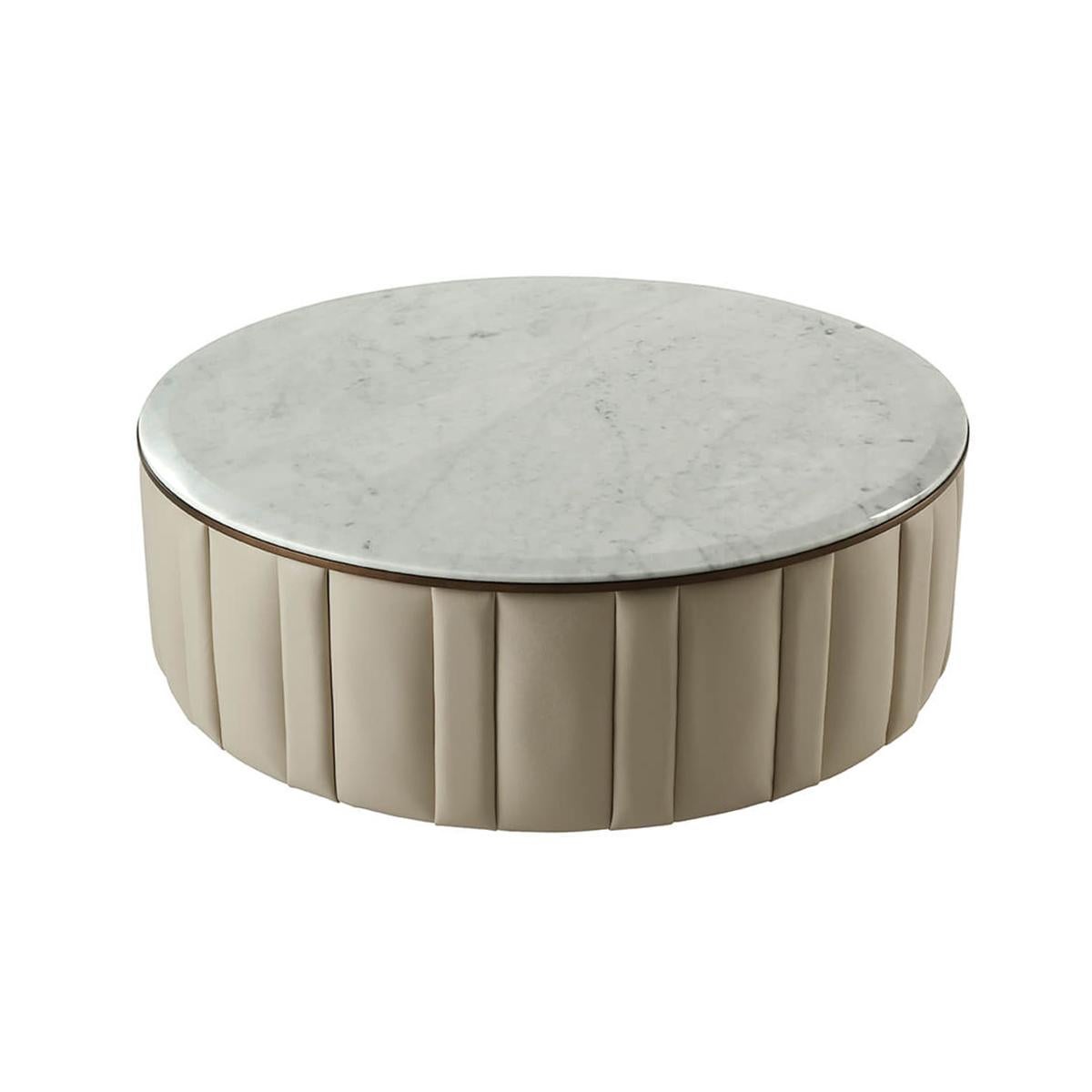 Avec un plateau rond en marbre Bianco Carrara à bord biseauté, avec des côtés rembourrés en cuir dans un design cannelé avec une moulure de finition Heritage Bronze.
Dimensions : 47.25