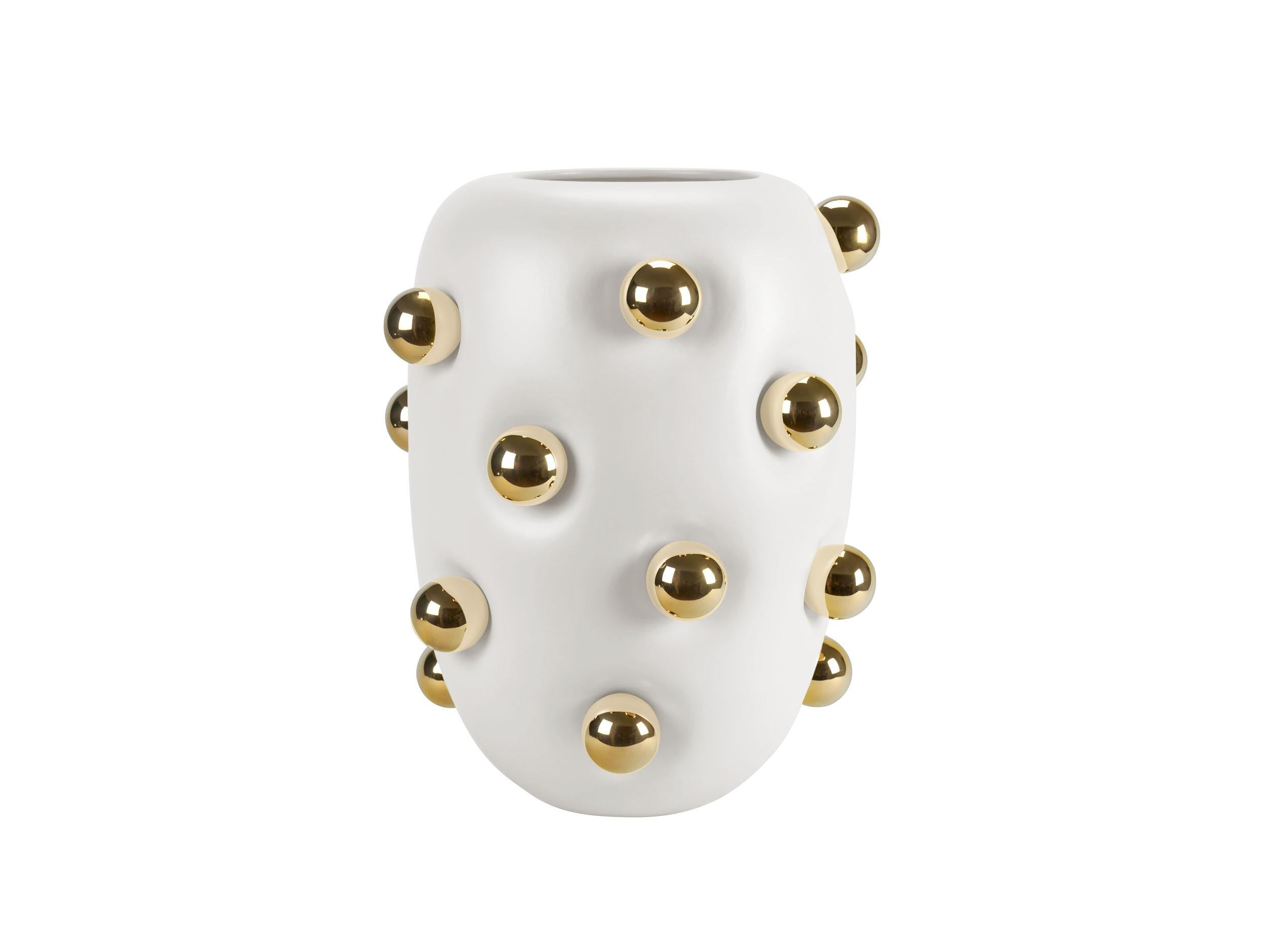 Contemporary ceramic vase in white, adorned with 19 ceramic spheres plated in 24-karat gold. The body of the vase features a matte finish that enhances its unique shape, giving the impression that it is made of a soft, pliable material that deforms