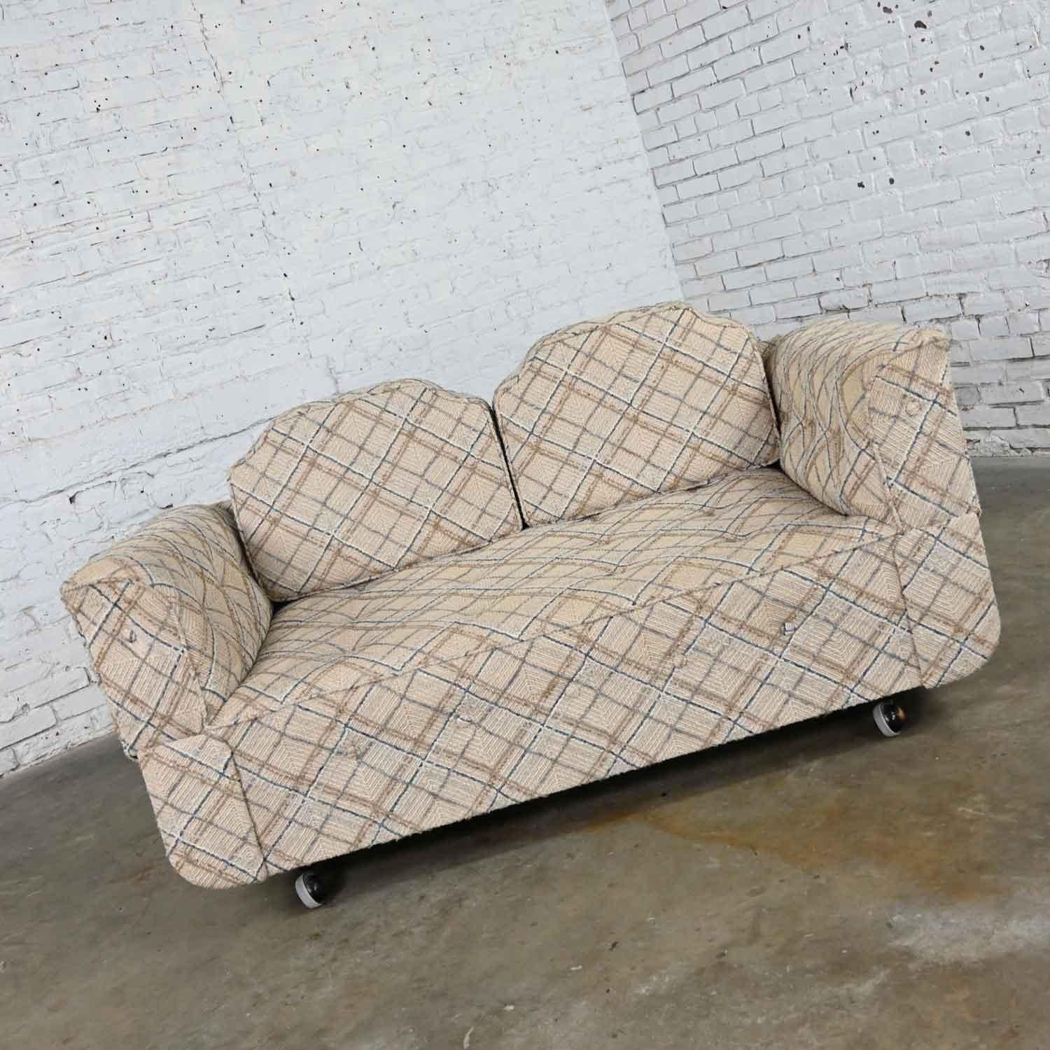 Wonderful convertible love seat sofa, daybed or chaise with casters in the front and tapered wood legs in the back and blue and brown on oatmeal colored base plaid pattern fabric. Beautiful condition, keeping in mind that this is vintage and not new