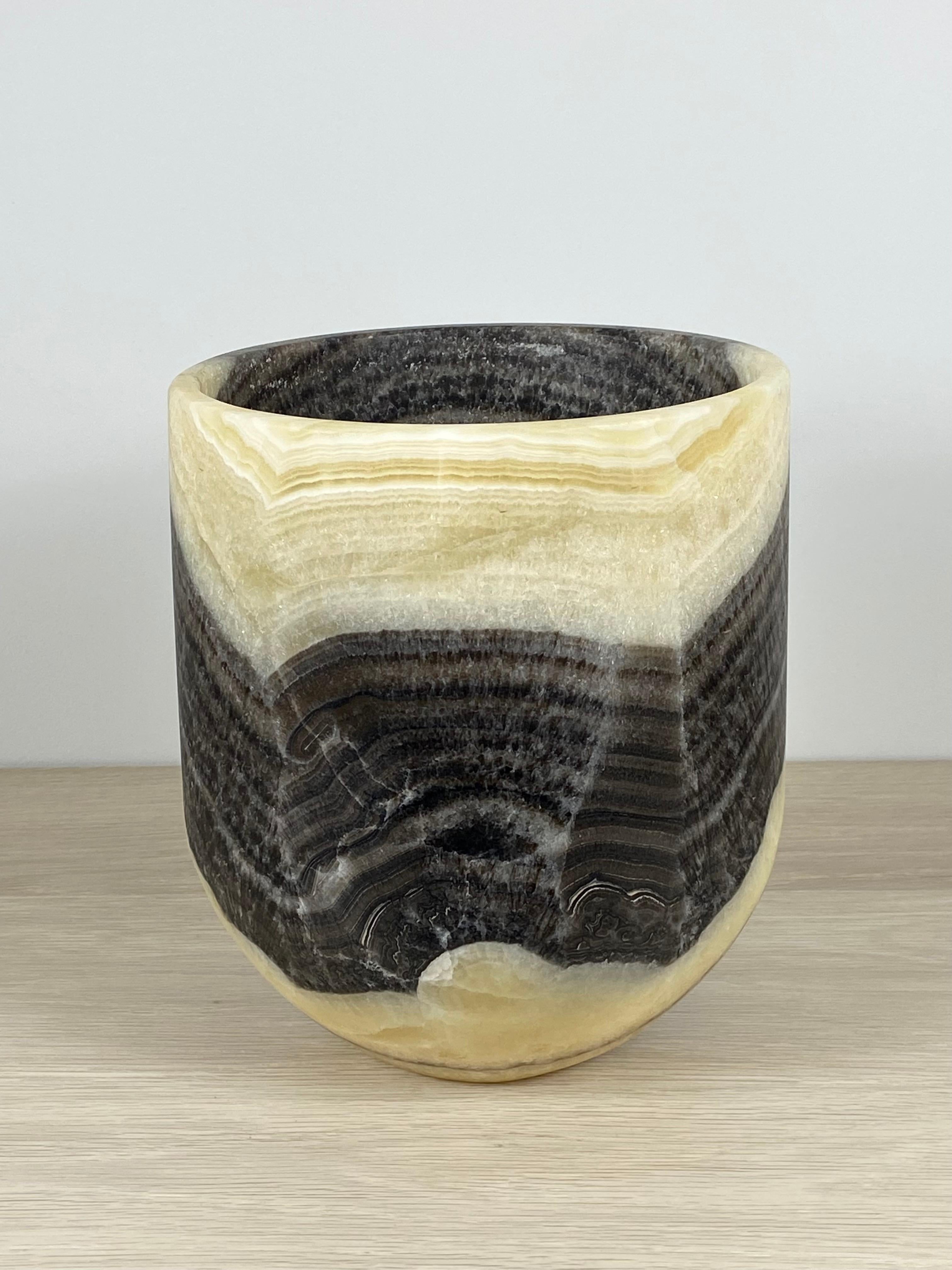 An unusual striped onyx planter. This one of a kind planter is meticulously hand-carved from a single piece of raw stone by skilled artists to reveal its' inherent characteristics. The striations are formations formed over thousands of years. This