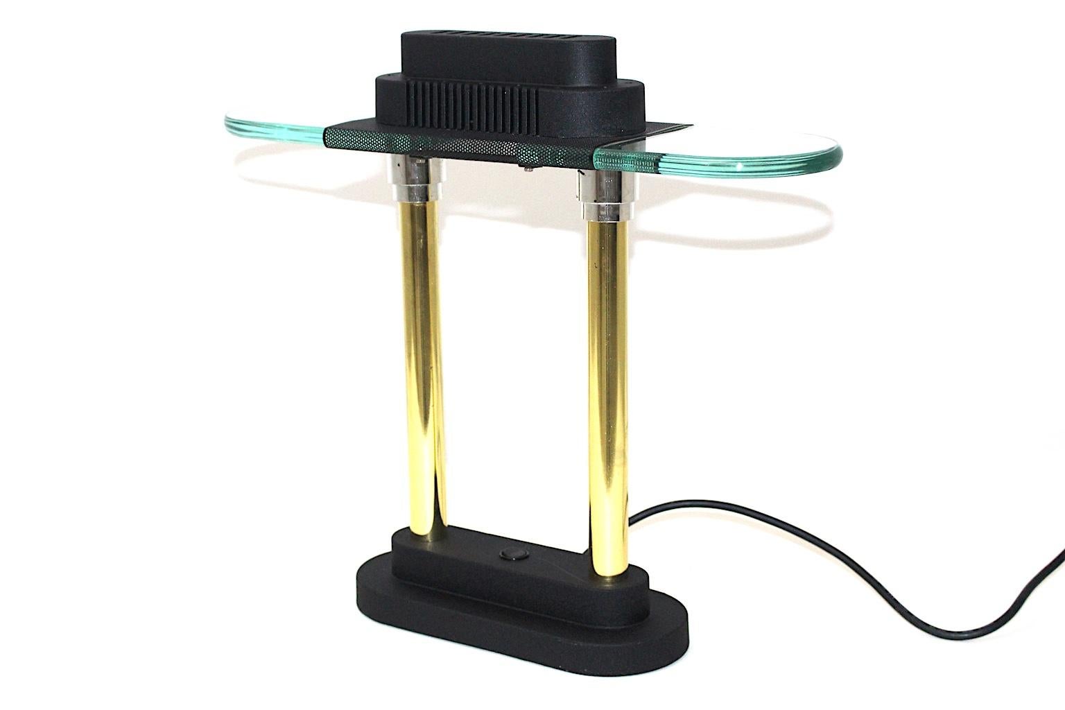 The modern Memphis style metal and glass vintage table lamp was designed by Robert Sonneman 1987 and produced by George Kovacs, USA.
Furthermore the Memphis style table lamp was made of brass, chrome, black lacquered metal and glass. Also the table