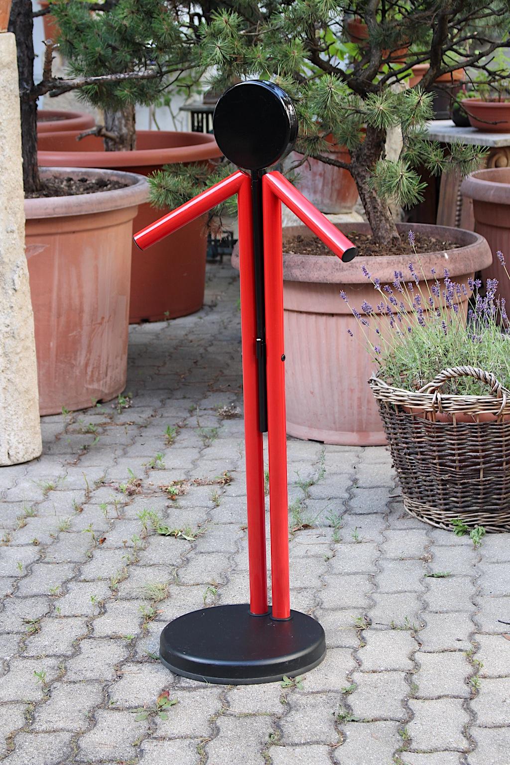Modern Memphis style vintage red and black metal valet, which was designed and manufactured in Italy, 1980s.
While two red lacquered tubes features the hooks for your clothing and jacket, a black fold out tray takes your accessories. The extended