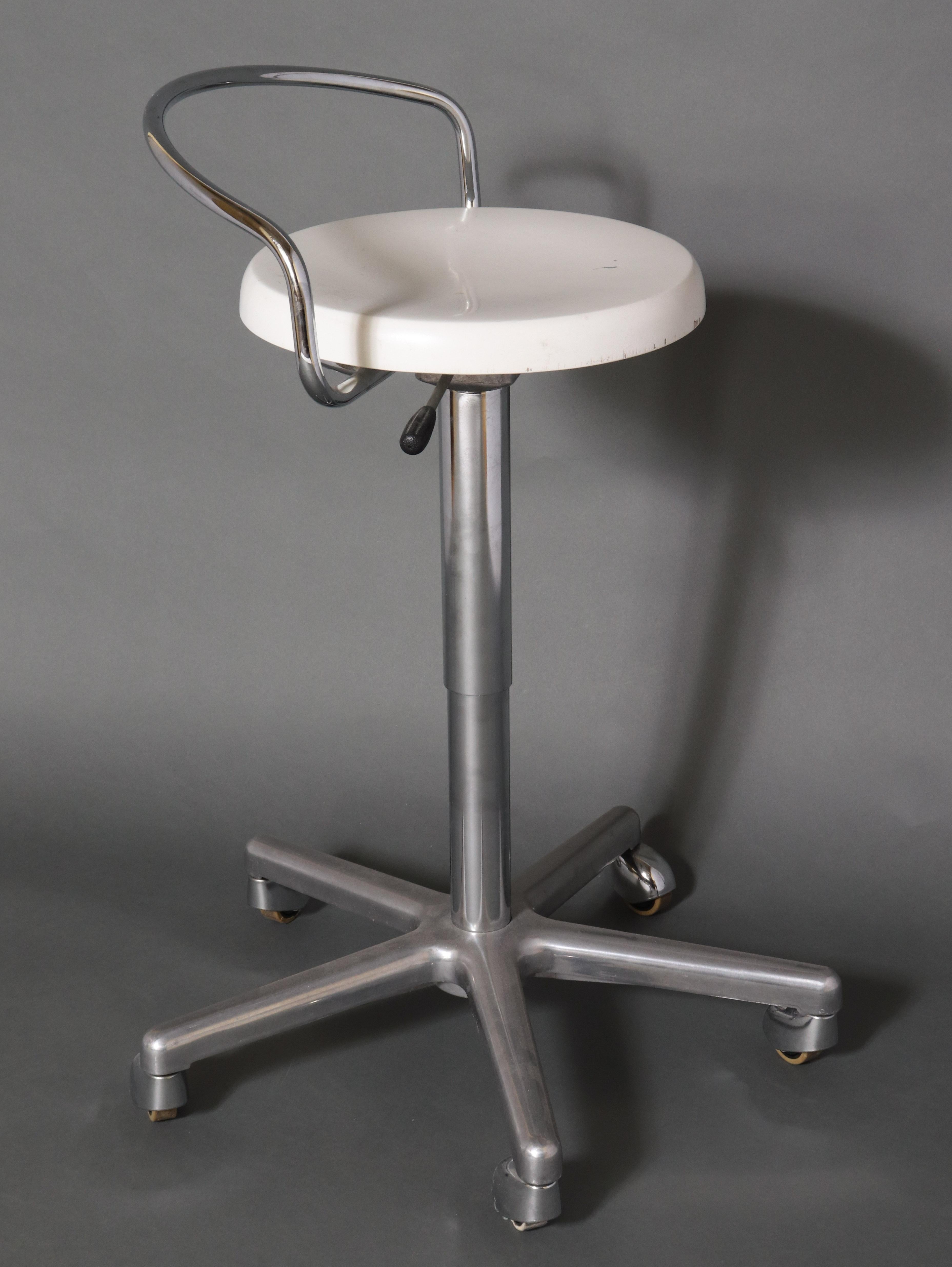 Modern metal swivel stool with adjustable height. The piece is on casters and has a low metal back bar with a white seat made of composite material. In great vintage condition with some age-appropriate wear and use.