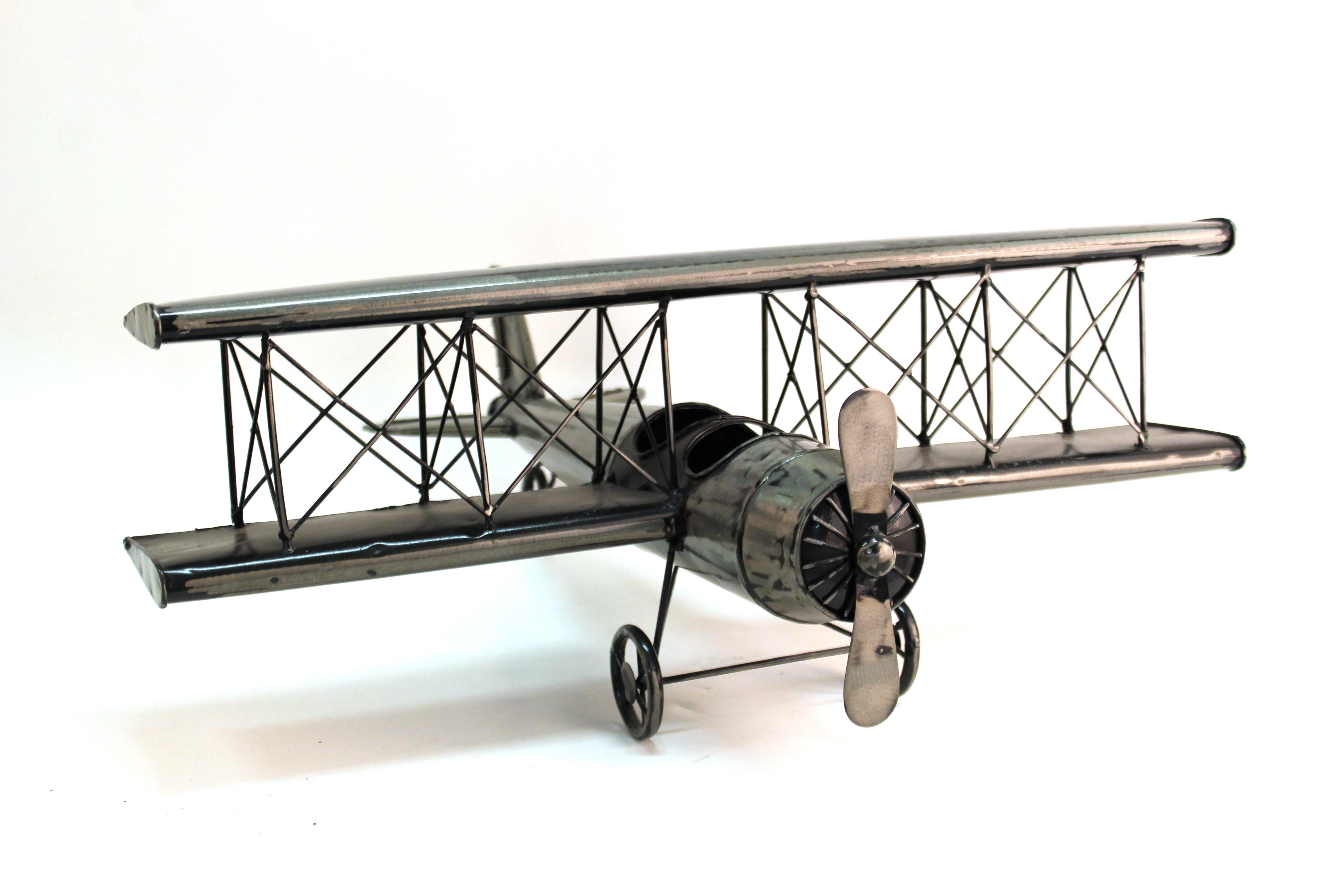 Modern metal built collectible scale model of a vintage airplane. The piece has a rotating propeller. In great vintage condition with age-appropriate wear and use.