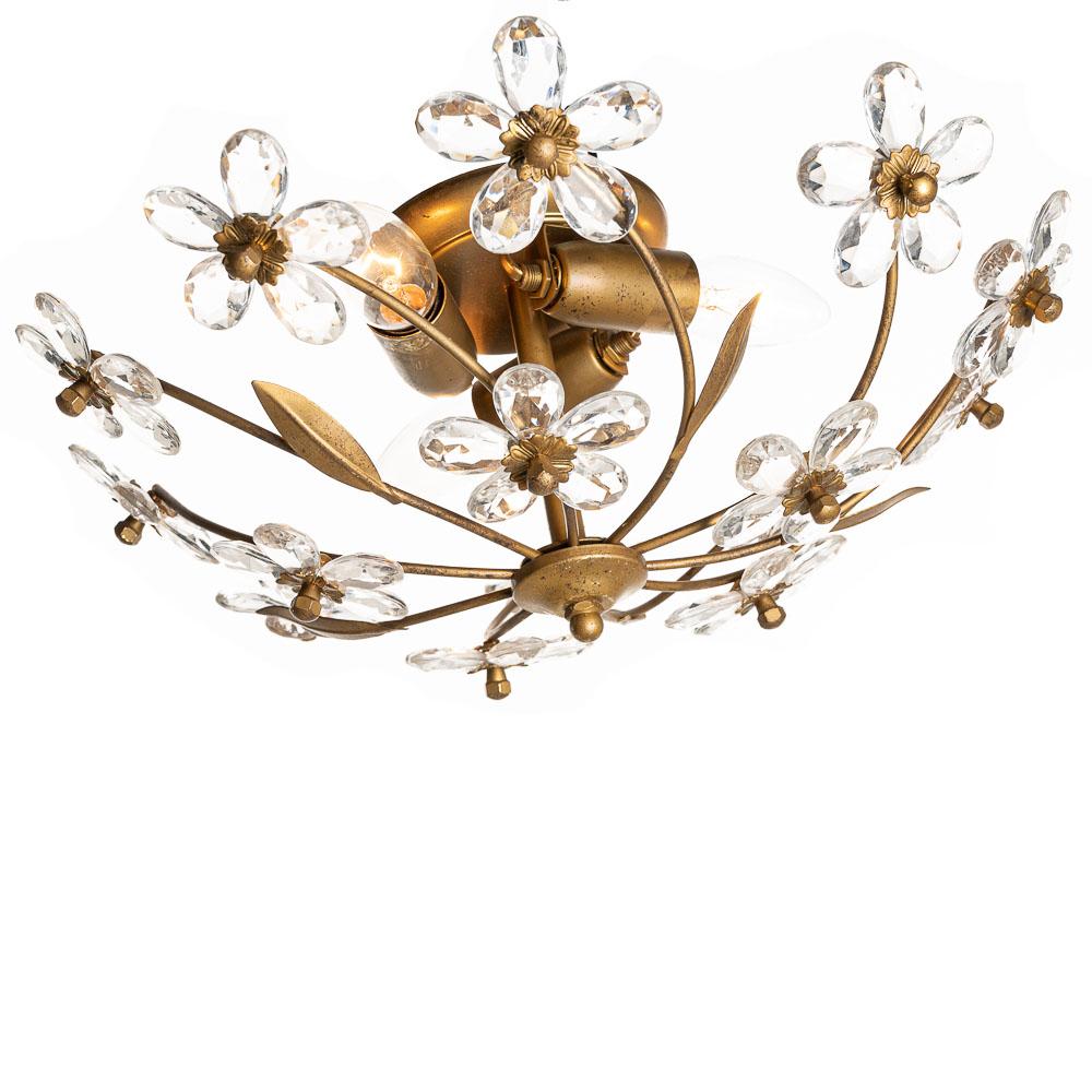 Brass-colored arms branch out from the base with beautifully ornate leaves to crystal flowers. The base contains three connections for E14 bulbs.