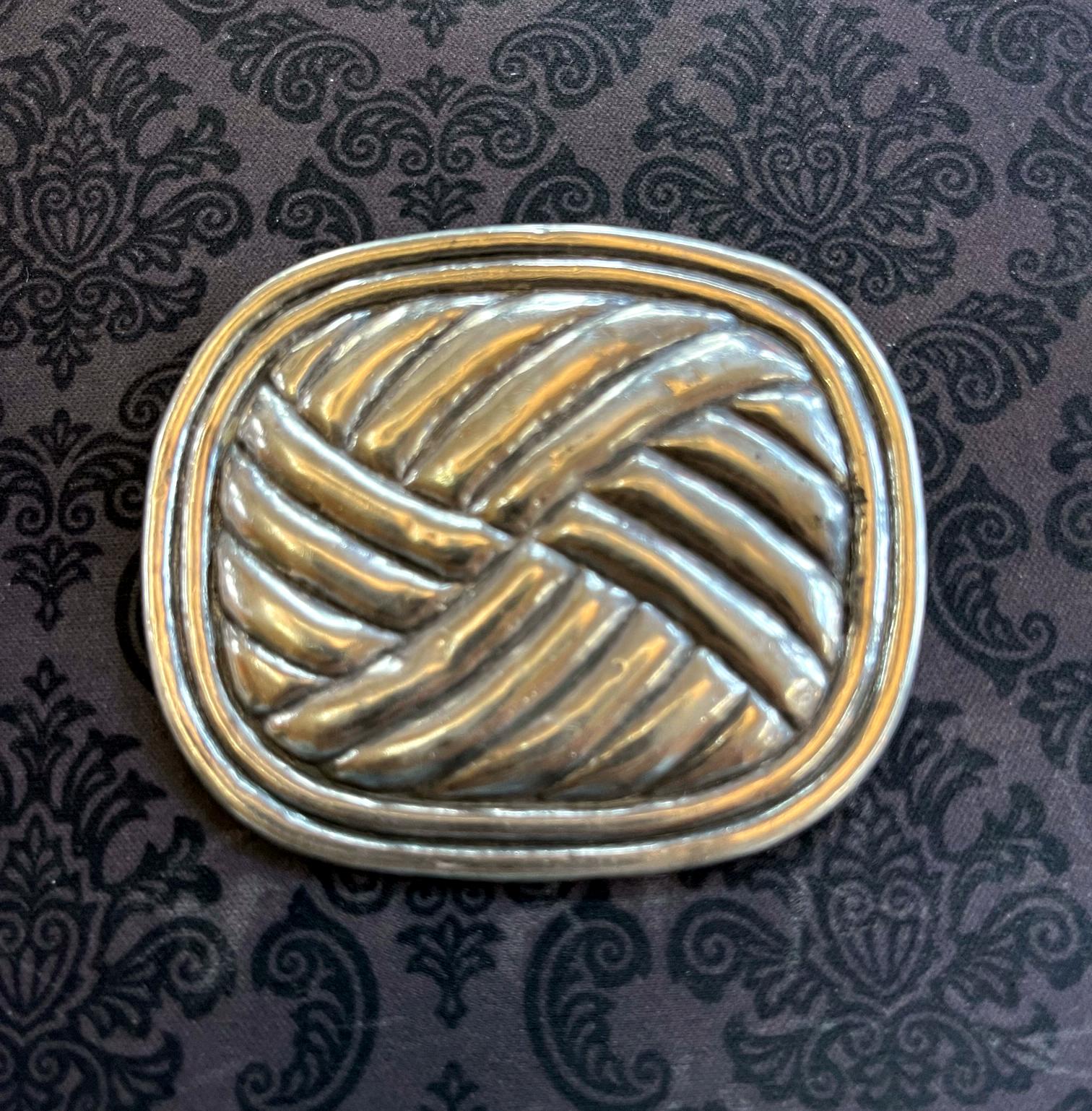 A modernistic sterling silver brooch by William Spratling from the first period 1940-1944. Made in his studio in Taxco, Mexico. The brooch features an abstract woven motif within a border, inspired by indigenous basketry. Stamped verso for William