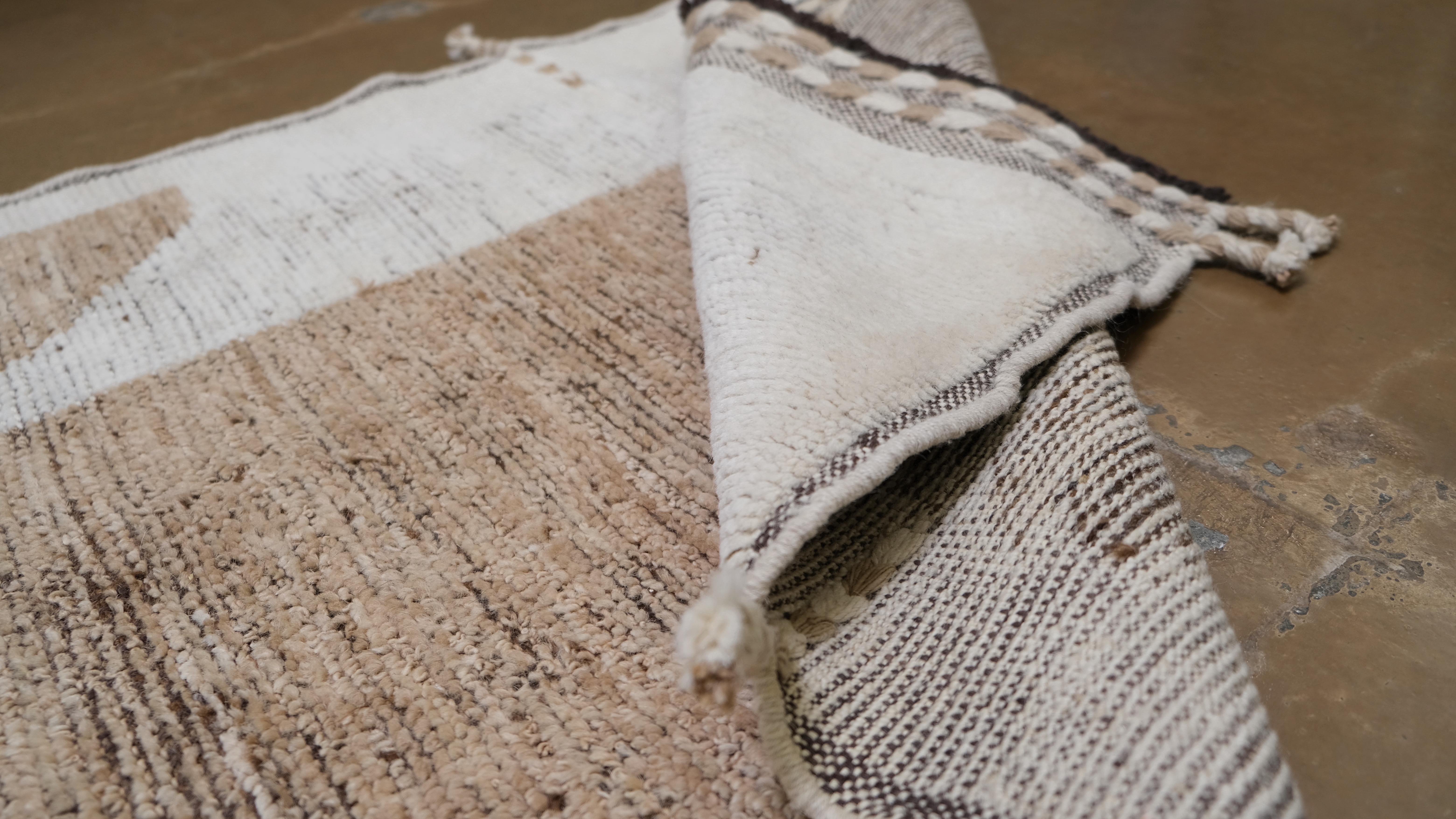 Add a bold statement to your interior with this hand-knotted wool runner rug. Featuring a striking modern geometric design in neutral beige and brown tones, this rug seamlessly combines artistry and functionality. Its contemporary pattern,
