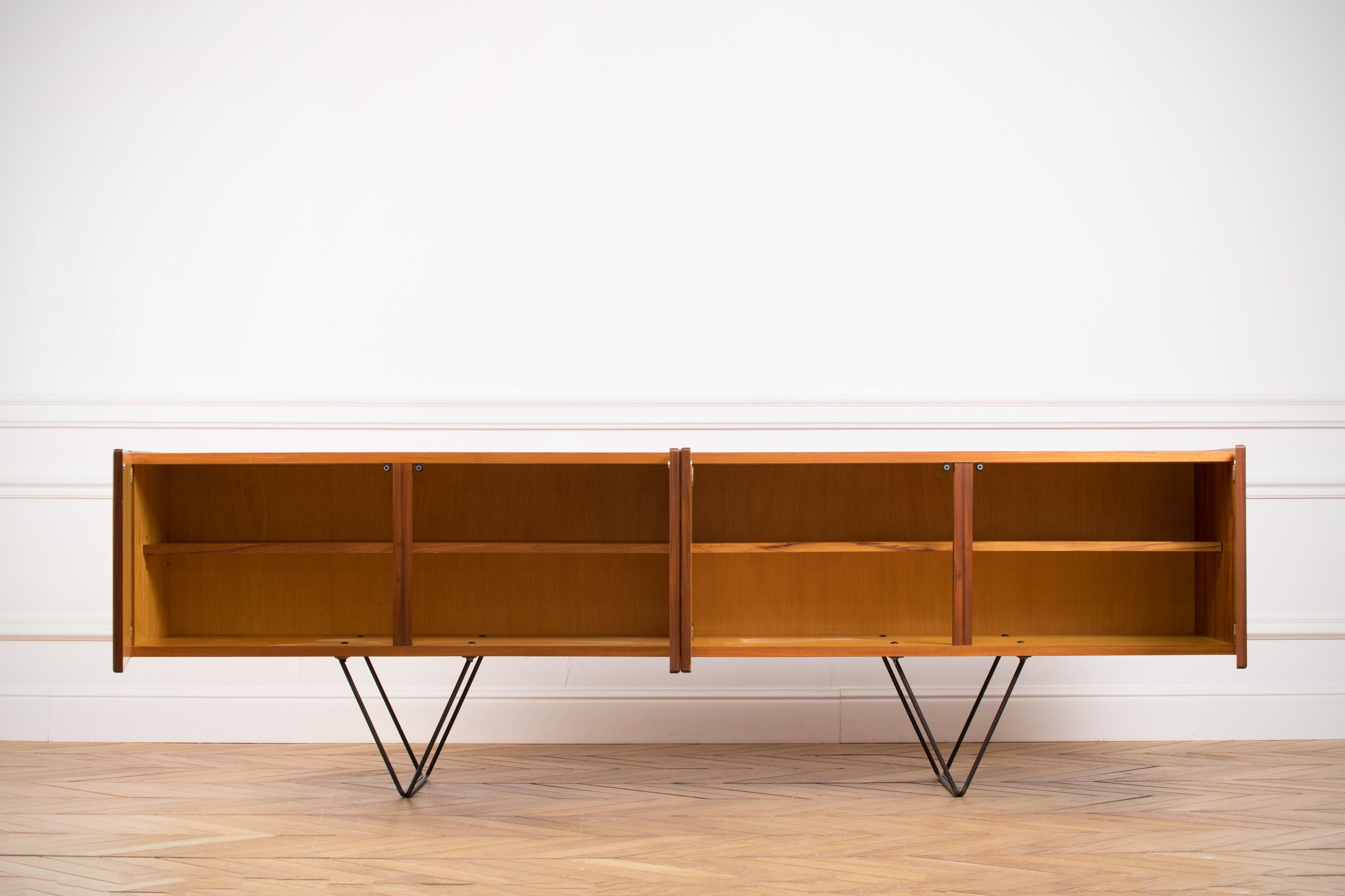 Midcentury teak sideboard from the 1960s. Beautiful minimal legs and carefully hollowed out discreet handles. The storage consists of two large sized cupboards with middle shelves.
This classic credenza will enhance the interiors of all styles.