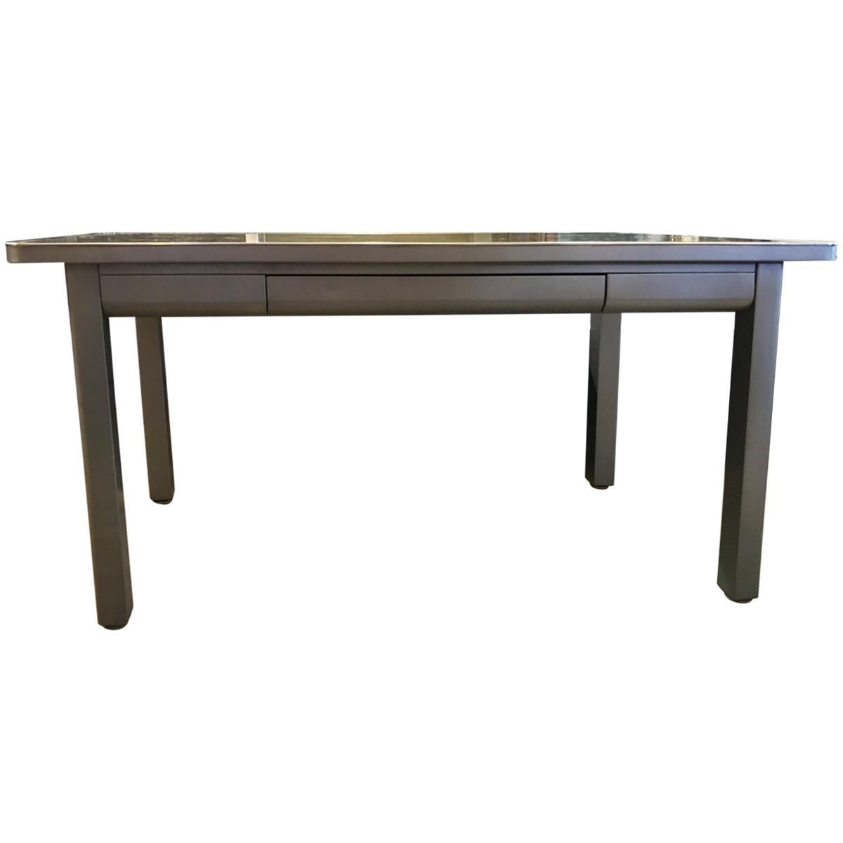 Industrial interior design showcases neutral tones, utilitarian objects, and wood and metal surfaces, proudly displaying the building materials that many try to conceal. Sleek and sophisticated, this brushed steel writing desk features a