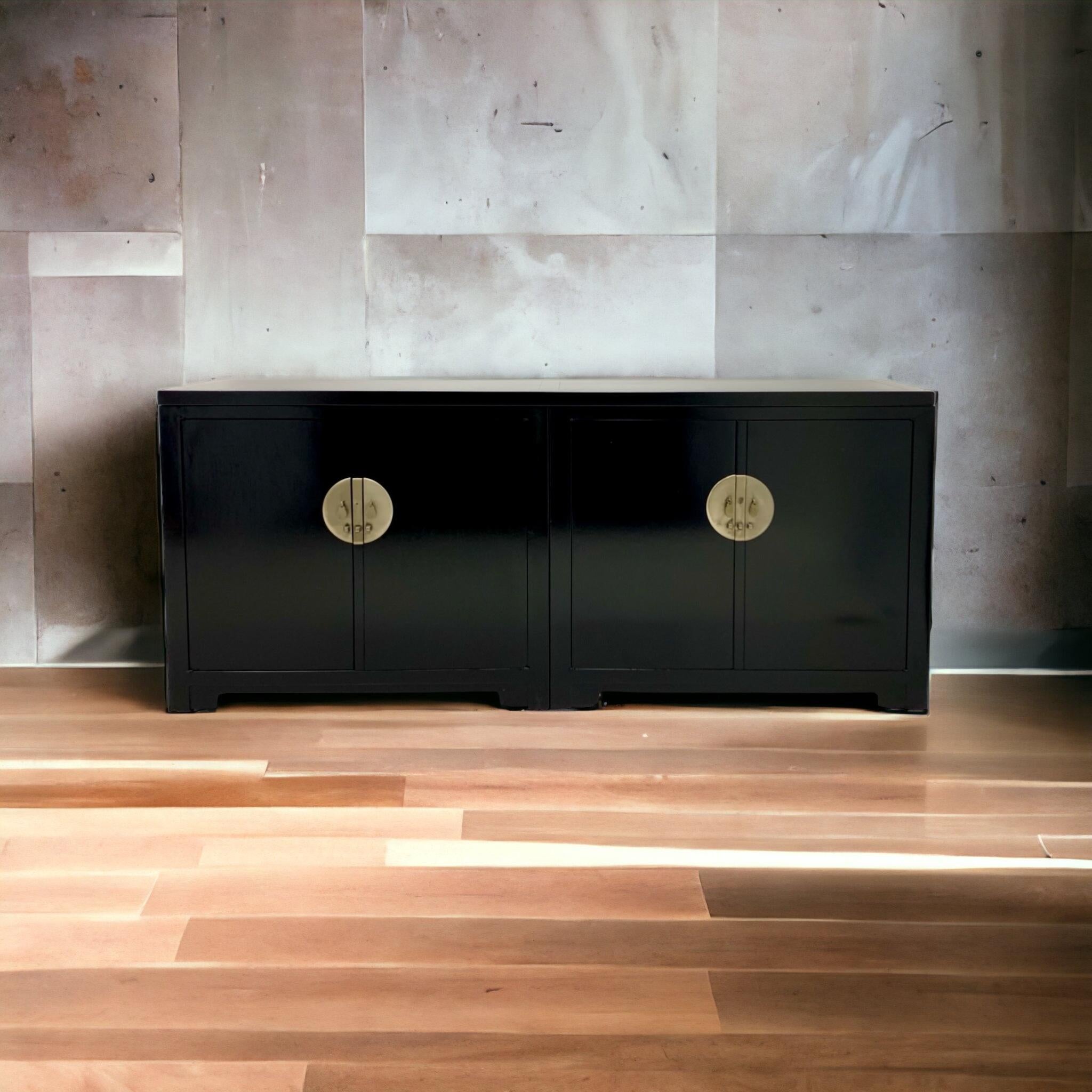 This is a handsome, timeless credenza designed by Michael Taylor for Baker Furniture as part of his Far East Collection. The black lacquer finish is recent. This is a three part credenza comprised of two cabinets and a long top. It opens to storage.