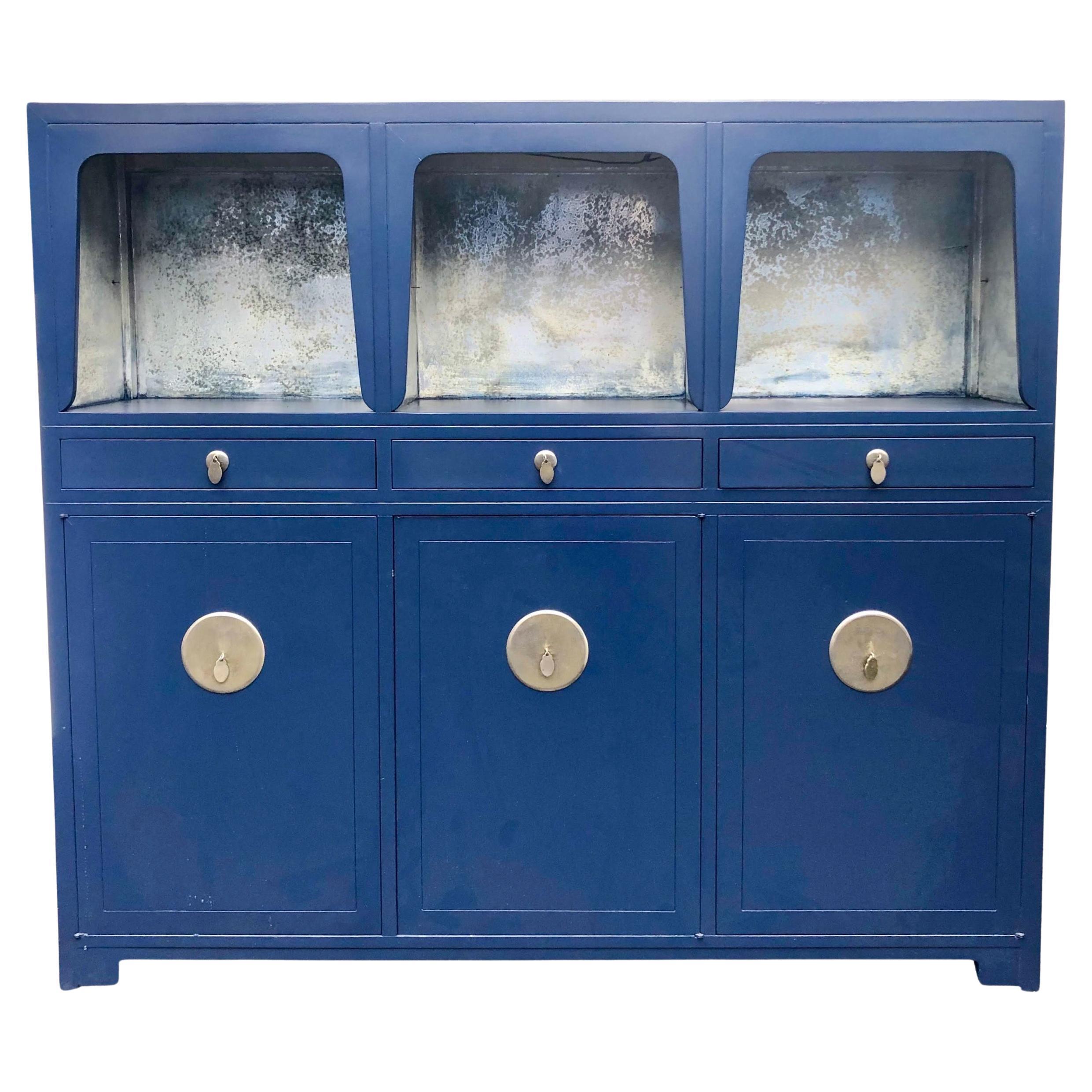 This is an Asian modern navy lacquered cabinet or credenza designed by Michael Taylor for Baker Furniture as part of his Far East Collection. The upper portion is silver leafed, while the base provides tremendous storage. 