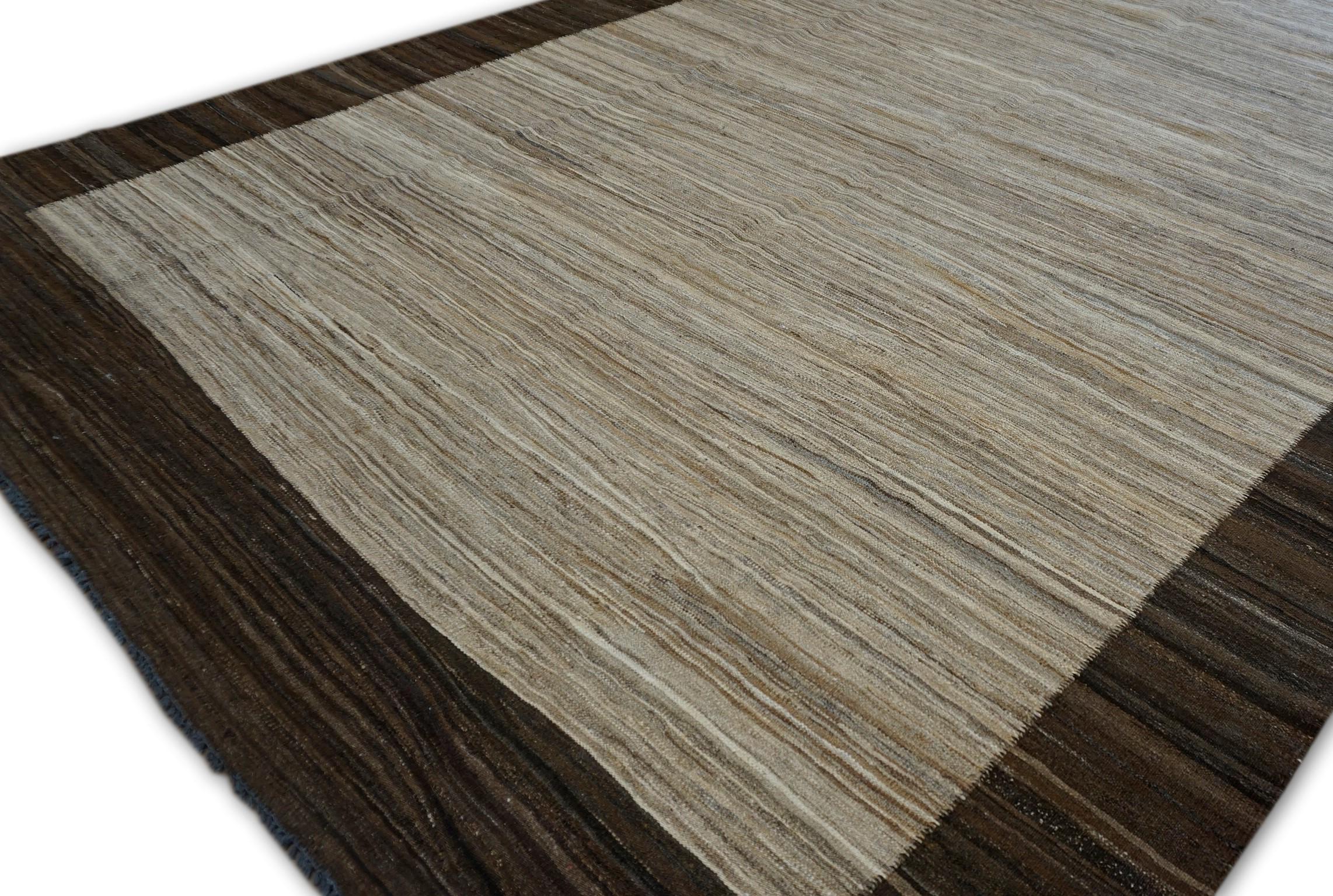 Dieser zeitgenössische, handgewebte Wollteppich verkörpert auf wunderbare Weise modernen Minimalismus und raffinierte Eleganz. Sie wird von erfahrenen Handwerkern gefertigt und zeichnet sich durch ein schlichtes Design aus, das sich durch seine