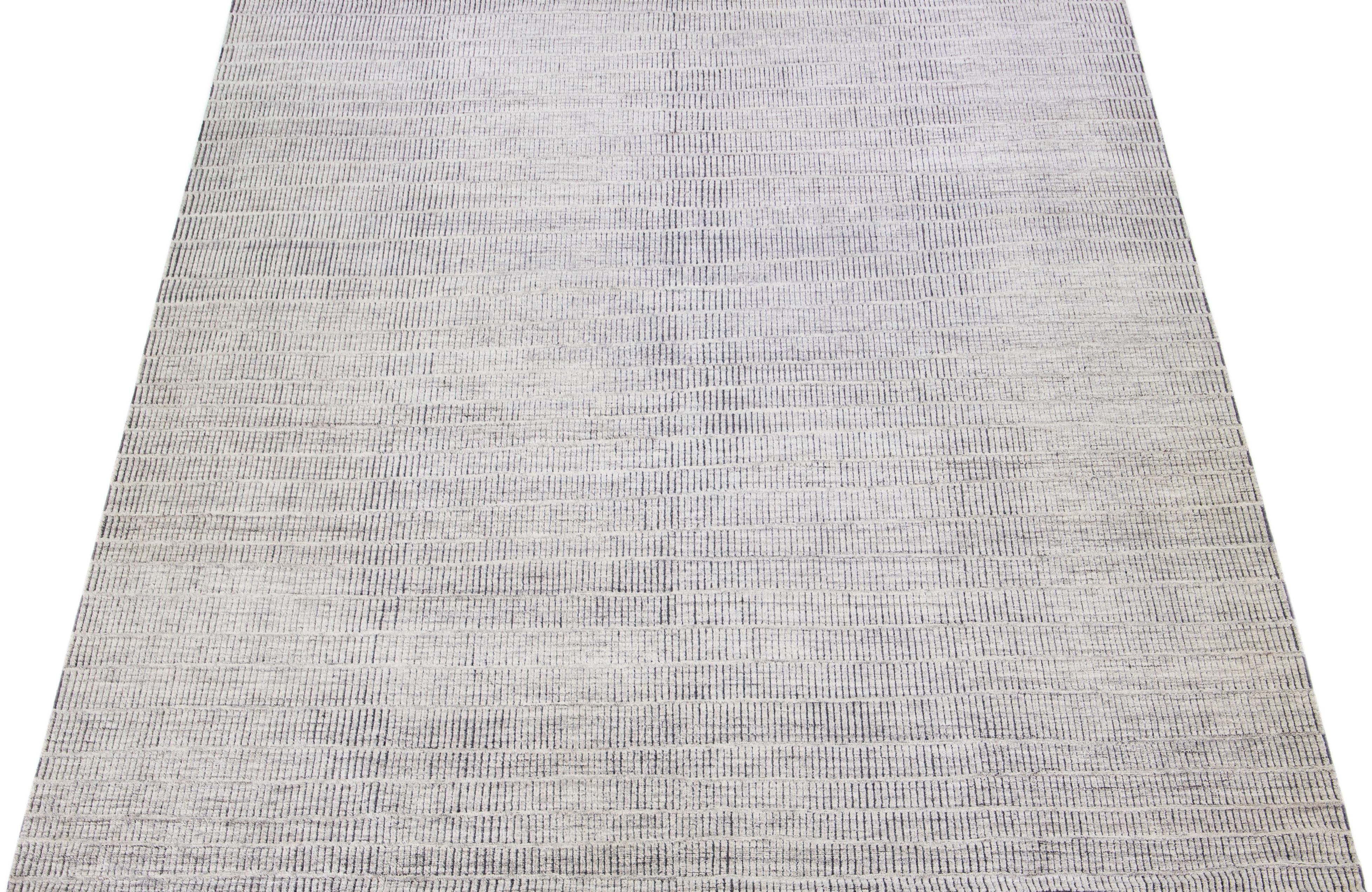 Beautiful modern Moroccan-style hand-knotted wool rug with a light gray color field. This rug is part of our Apadana's Safi Collection and features a minimalist design in dark gray.

This rug measures: 12'3