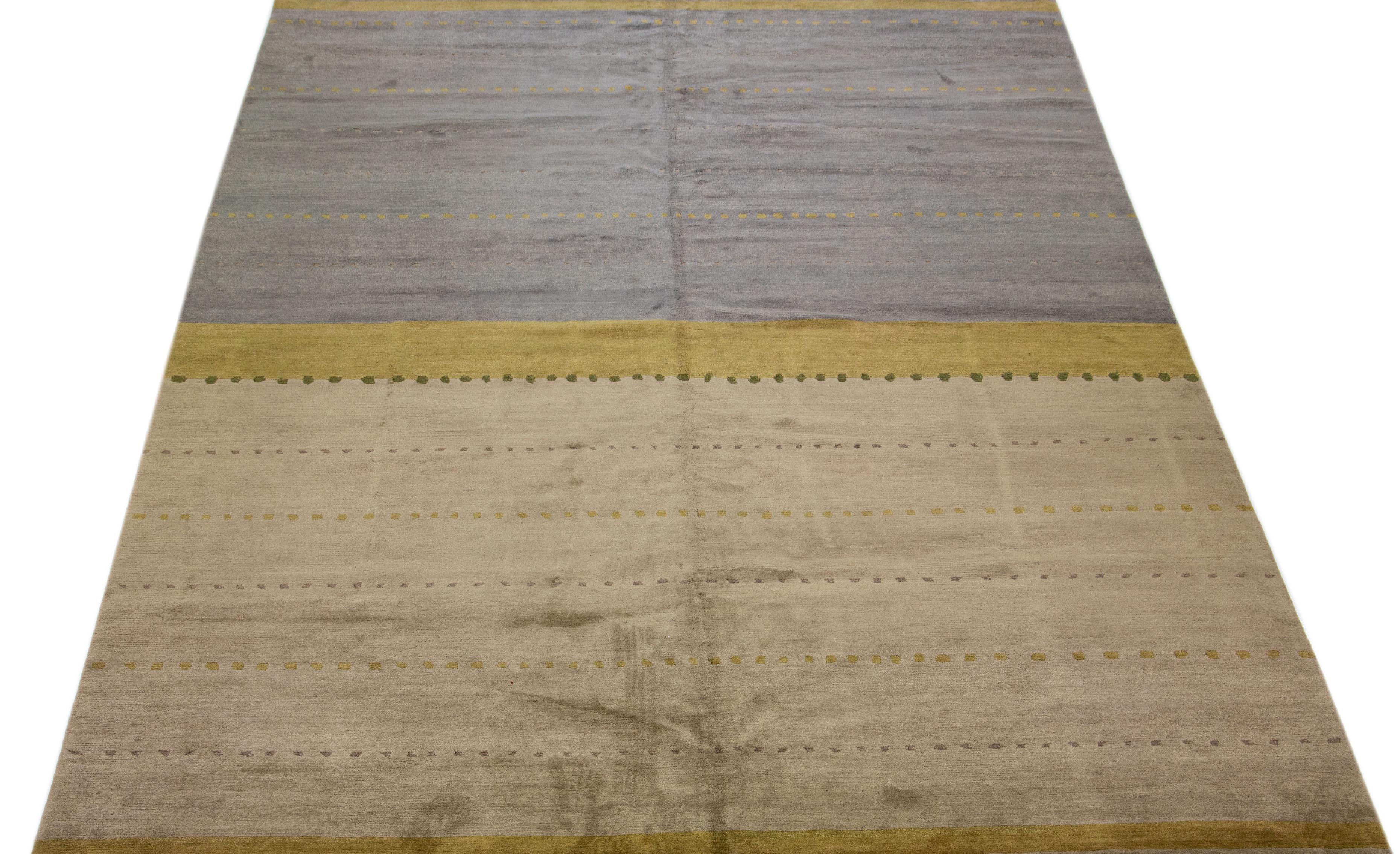 Magnifique tapis tibétain moderne en laine et soie nouée à la main avec un champ de couleurs gris et taupe. Ce tapis tibétain a un accent vert dans un magnifique design minimaliste.

Ce tapis mesure 10' x 14'.