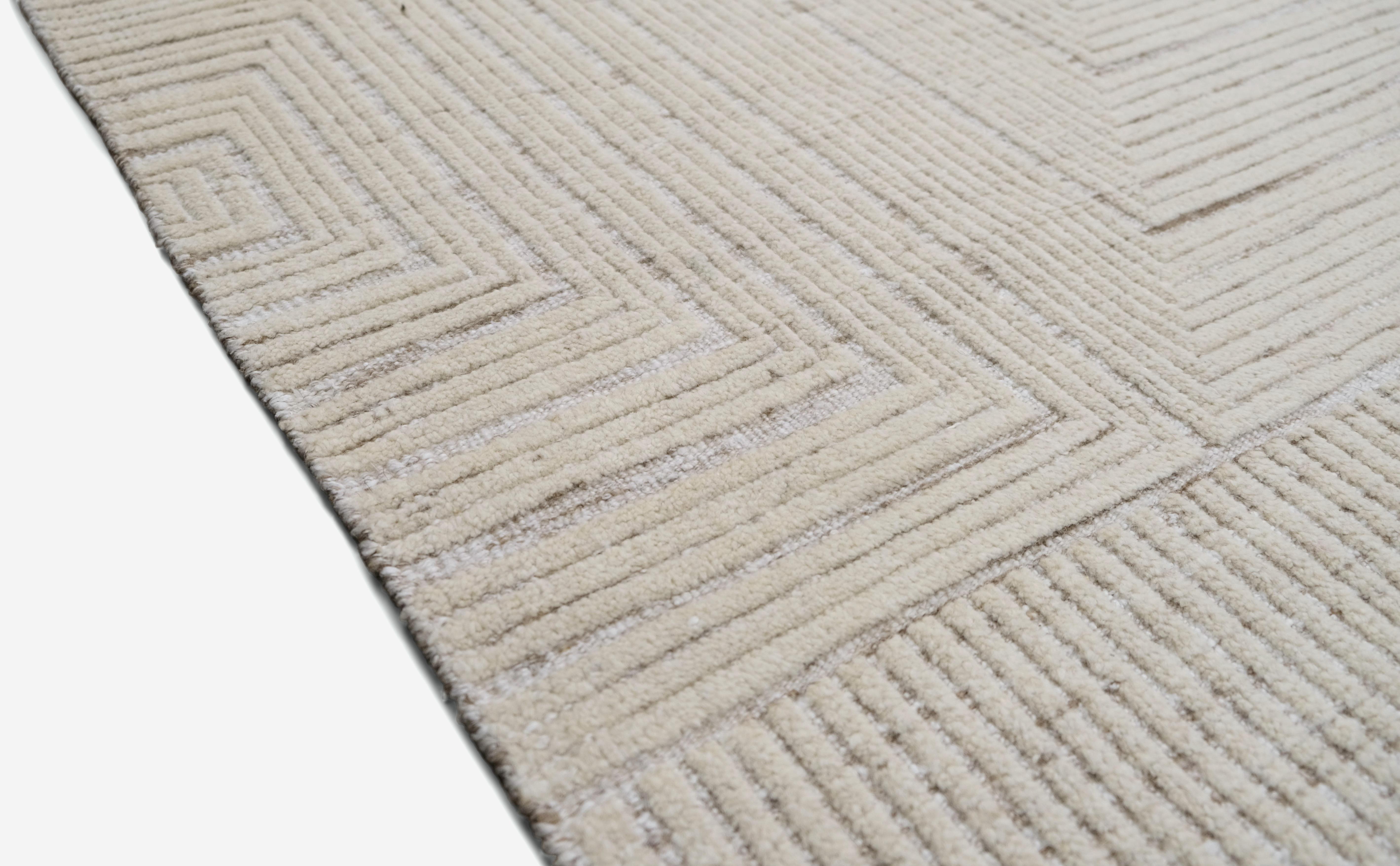 Bringen Sie schlichte Eleganz in Ihren Raum mit diesem exquisiten handgeknüpften Wollteppich. Mit seinem minimalistischen, geometrischen Muster schafft dieser Teppich durch subtile Linienführung ein raffiniertes und modernes Design. Der neutrale