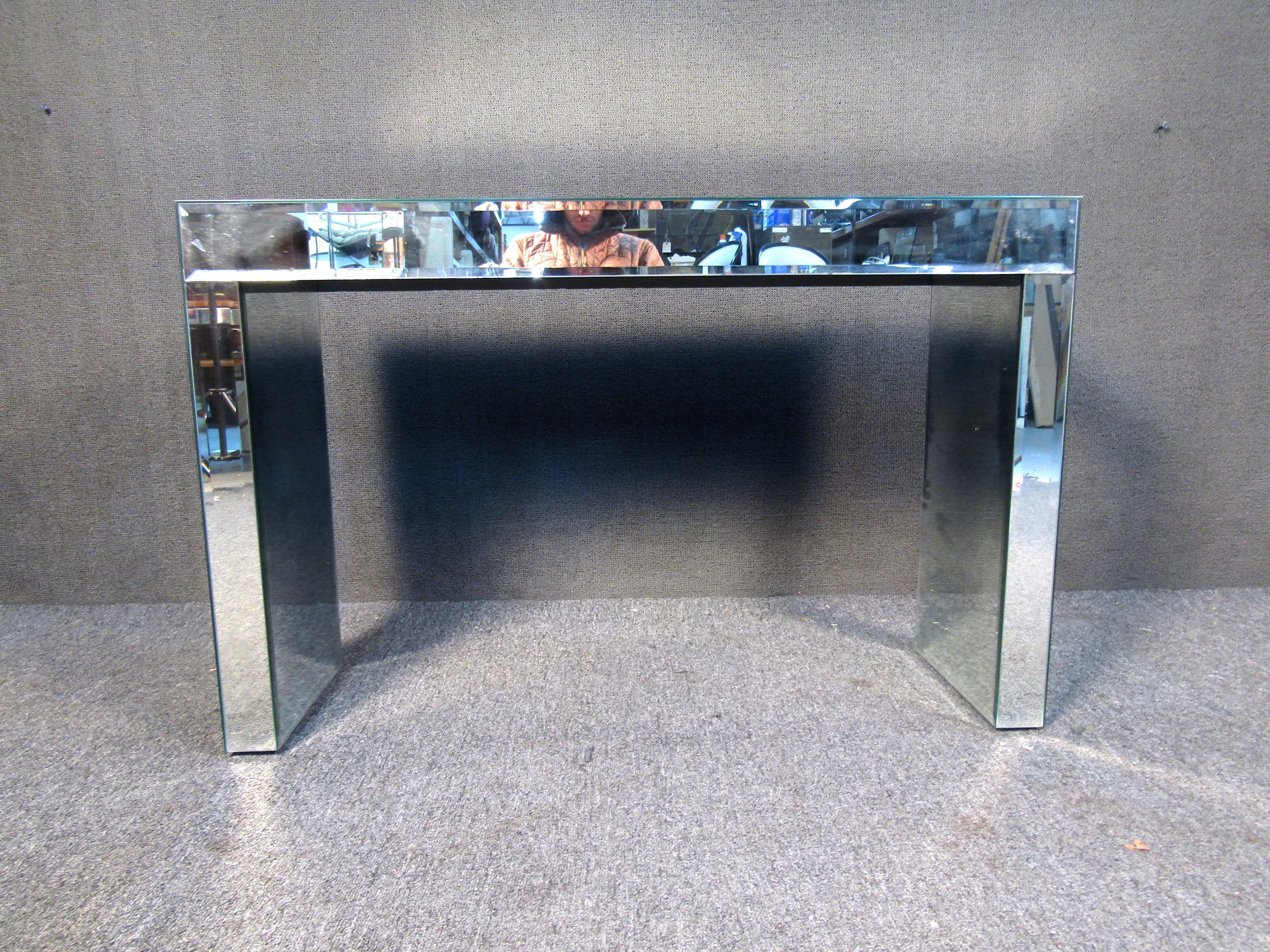 This unique mirror glass console table features sleek glass top and mirrored pedestal base. The perfect table for entryway, hall, or office display. Please confirm item location (NY or NJ.).