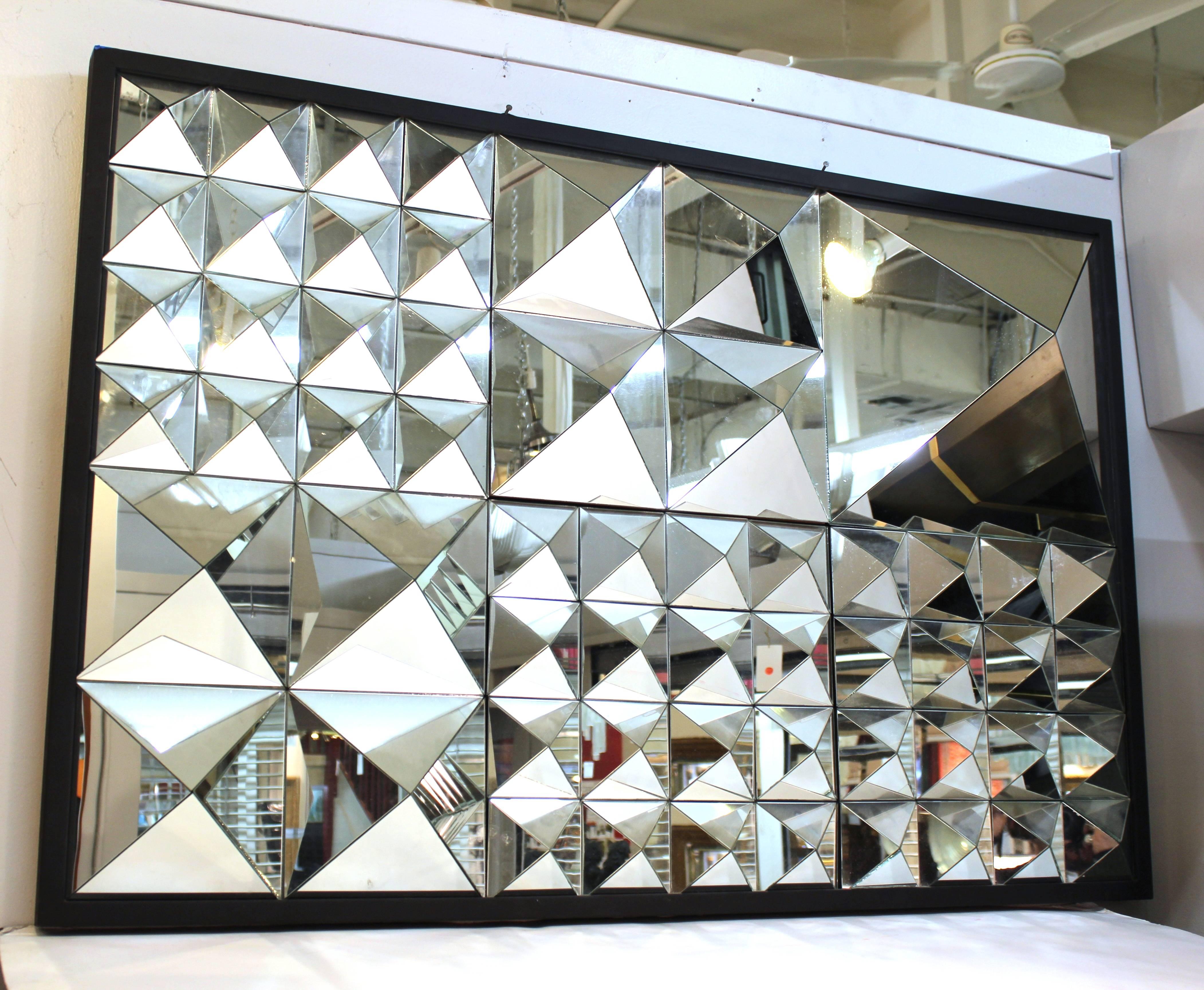 A modern geometric style mirror made up of multiple mirrored pyramidion shapes. The piece is in great vintage condition.