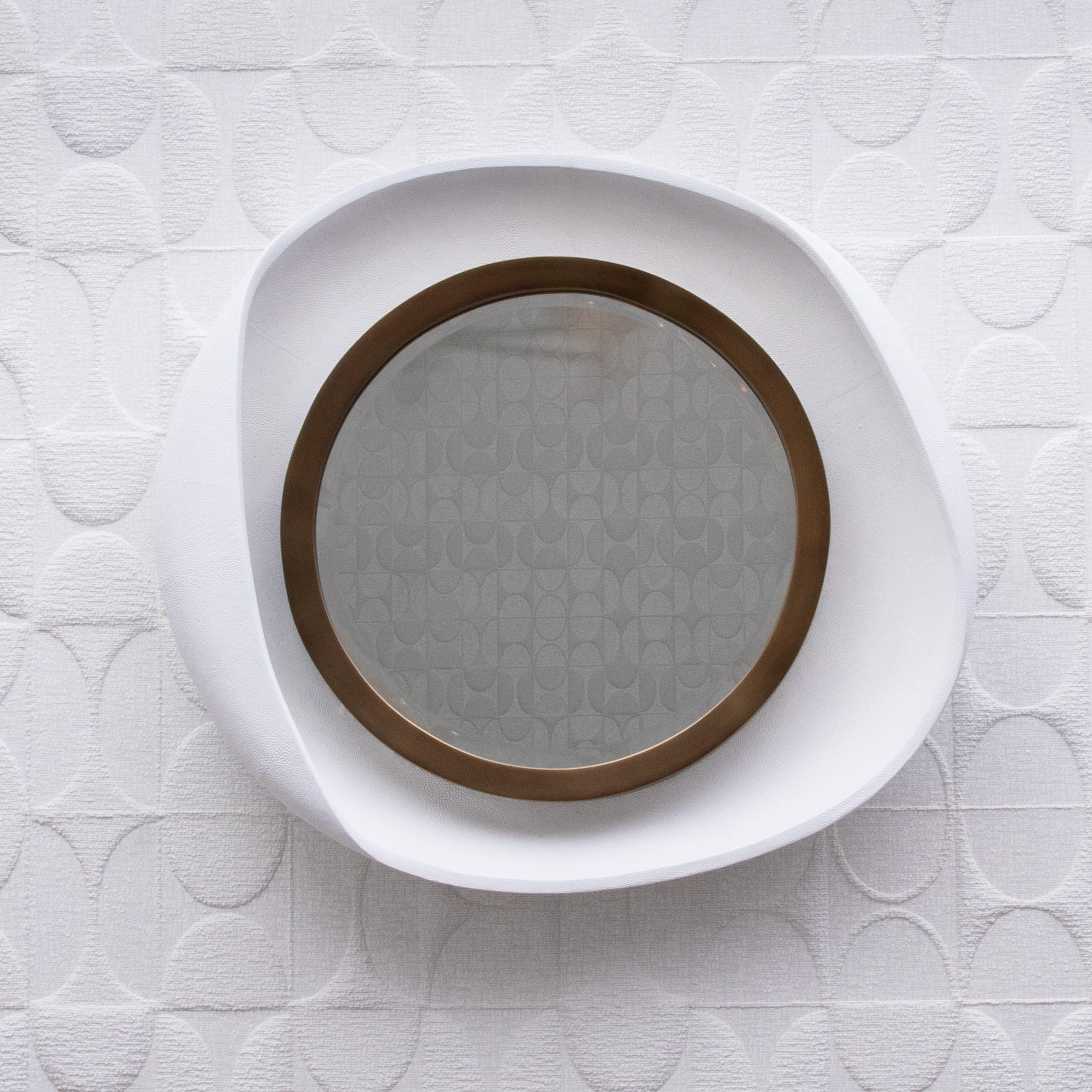 Lo specchio Petal di R&Y Augousti è un'elegante fusione di arte moderna e lusso senza tempo, che incarna la celebre estetica di ispirazione Art Deco del marchio. Realizzato a mano con un'impeccabile cornice esterna in zigrino bianco liscio, questo