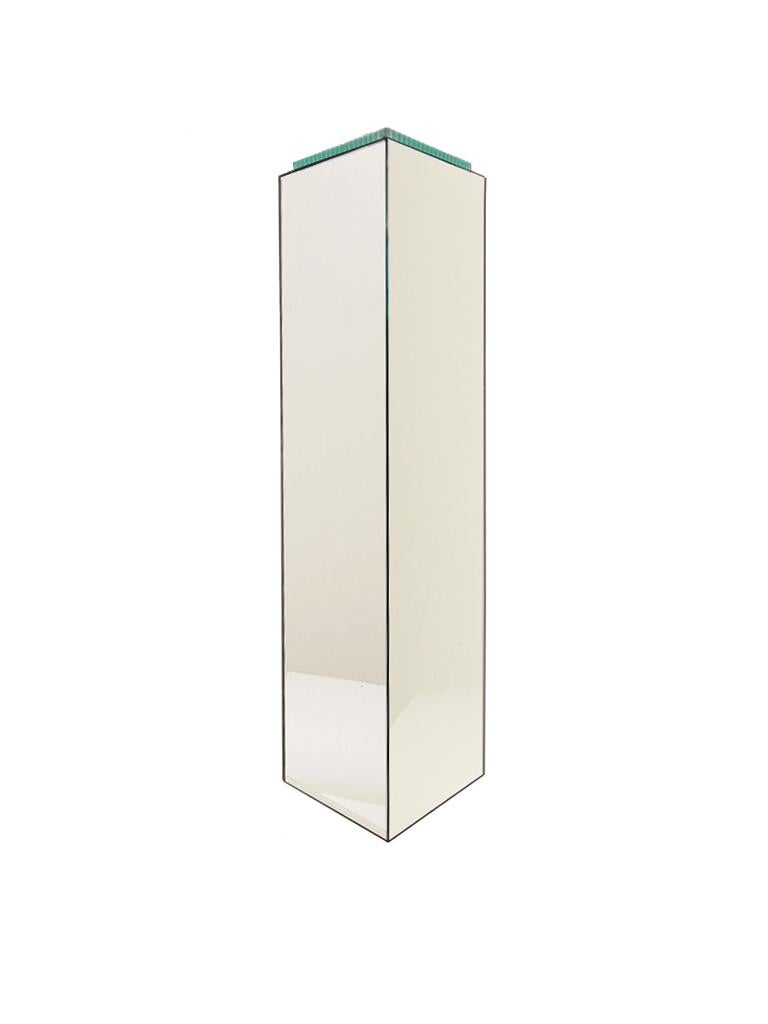 Exquisite mirrored pedestal designed by Juan Montoya. This pedestal consists of a volumetric rectangular body with modern mirrored panels and a beautiful blue glass top.

Property from esteemed interior designer Juan Montoya. Juan Montoya is one