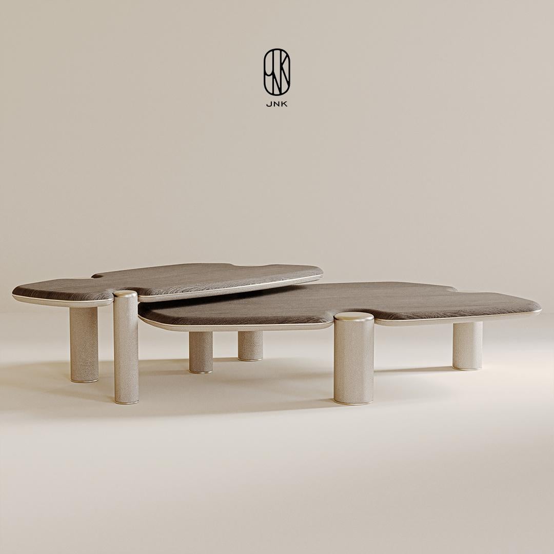 Set di tavolini da caffè Mone, 

Presenta un design minimalista con due pezzi separati. Le superfici morbide e organiche sono disposte a diverse altezze, creando un look moderno. Le gambe sono cilindriche e lisce e le superfici sono disponibili in