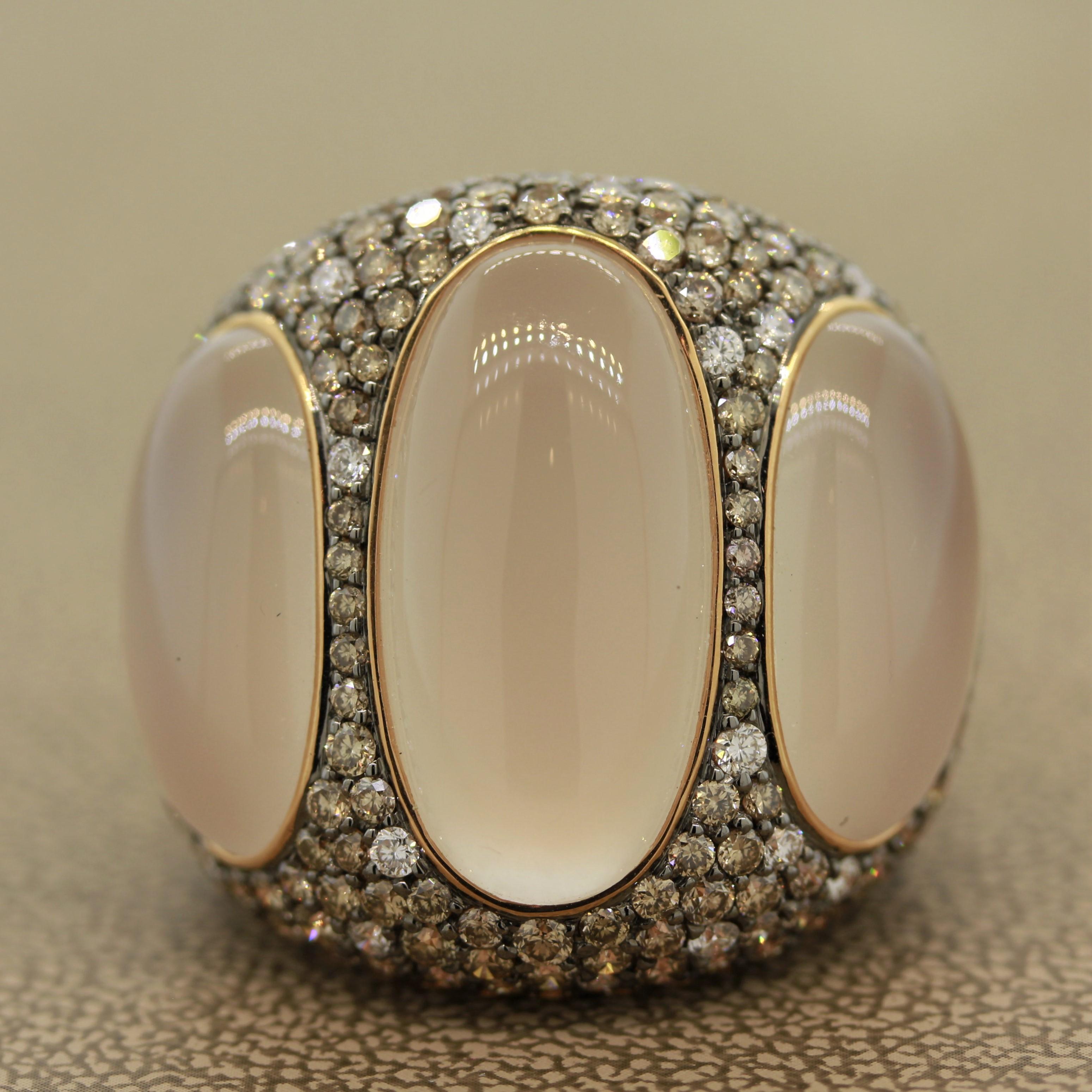 A lovely modern designed cocktail ring featuring 3 oval shaped cabochon moonstones weighing a total of 27.28 carats. They are surrounded by fancy colored diamonds cut are round brilliants and weighing a total of 5.16 carats. Hand fabricated in 18k