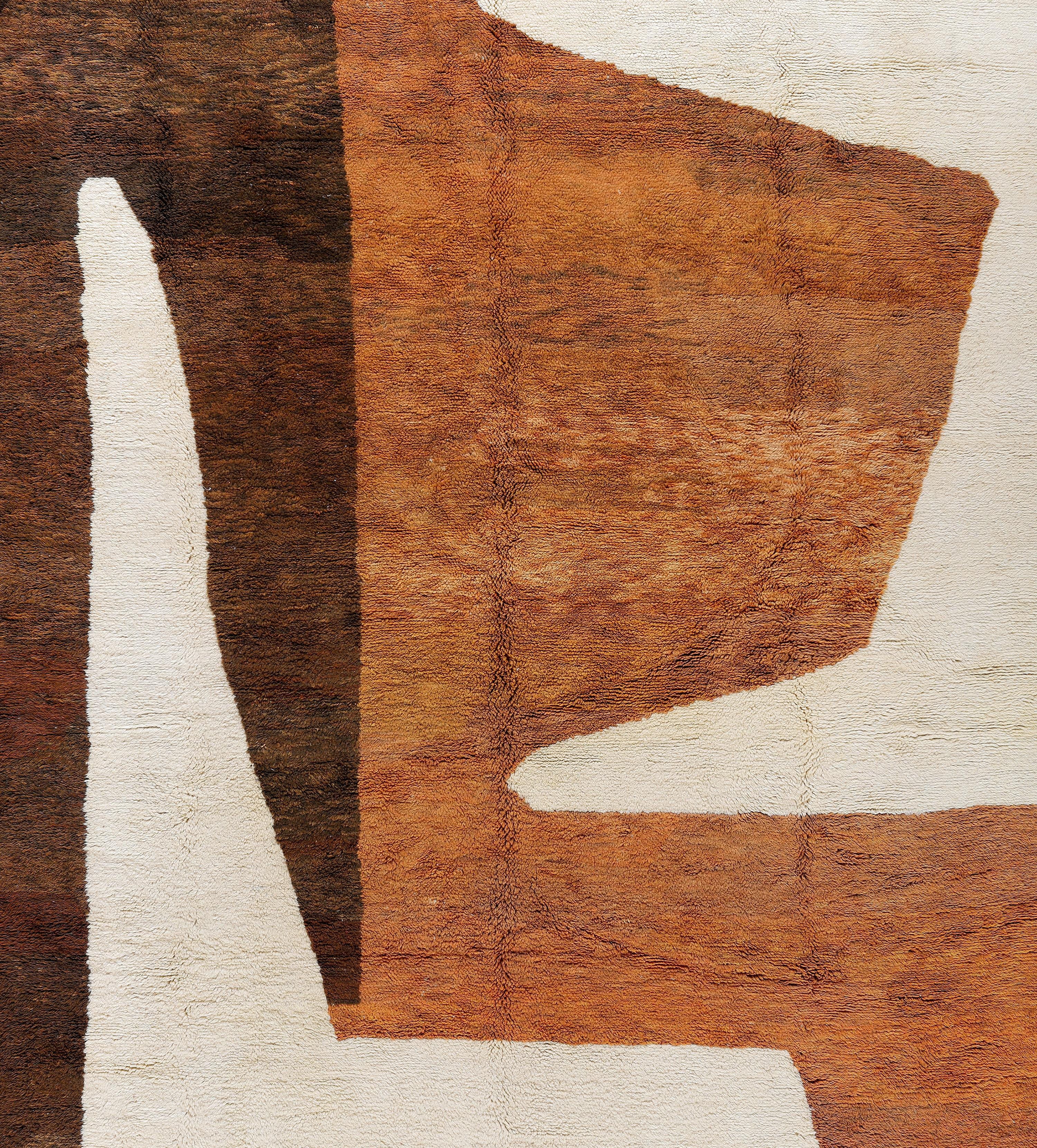 Esta alfombra marroquí Beni Mrirt, anudada a mano, es una audaz declaración artística con una impresionante composición abstracta en ricos tonos tierra: siena quemado, marrón chocolate y marfil. Tejida por hábiles artesanos en las montañas del Atlas