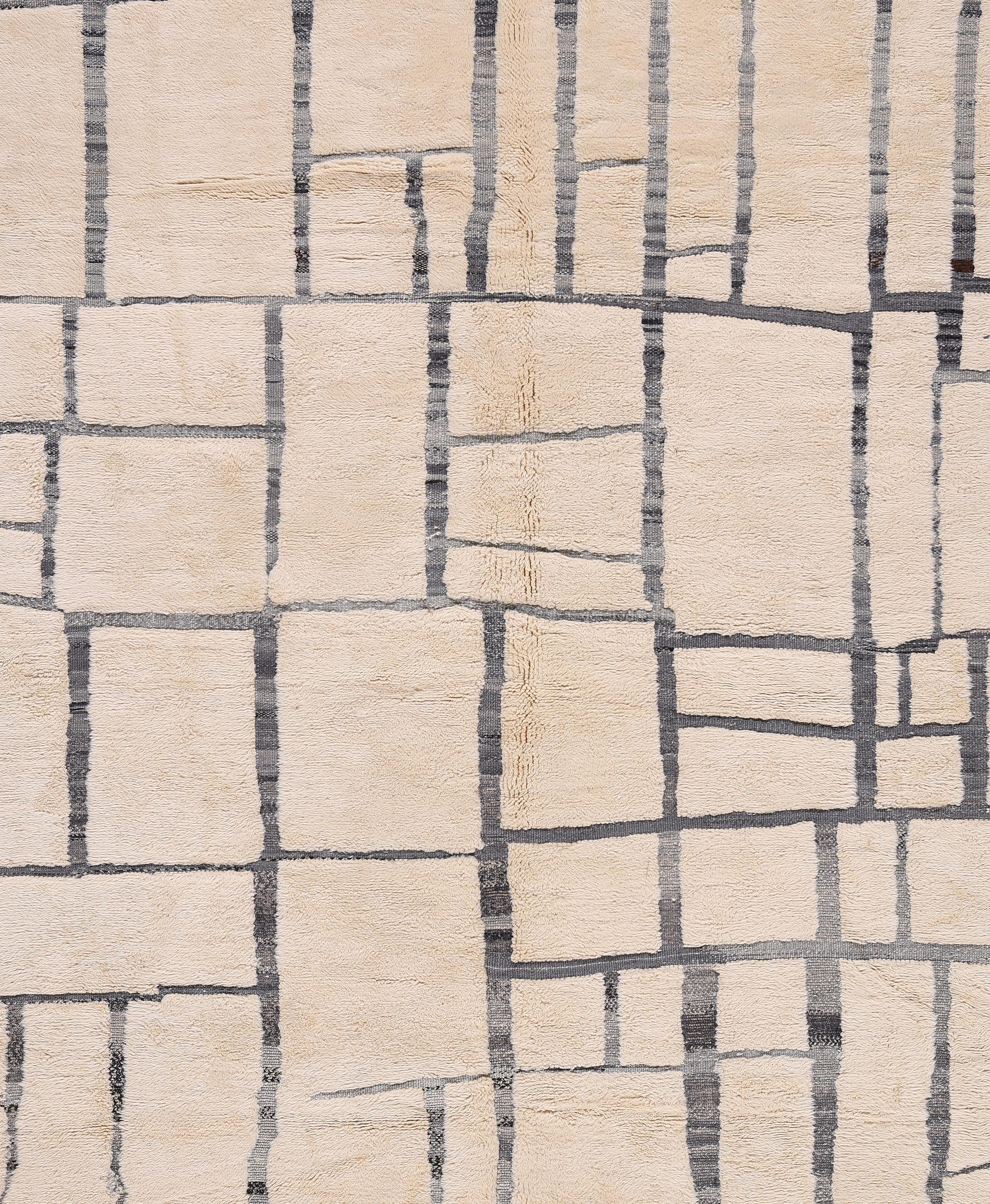 Eleva tu espacio con esta llamativa alfombra marroquí Beni Ourain tejida a mano, con un atrevido motivo de cuadrícula abstracta en color carbón oscuro sobre una cálida base de lana natural. Esta alfombra bereber contemporánea única en su género, de