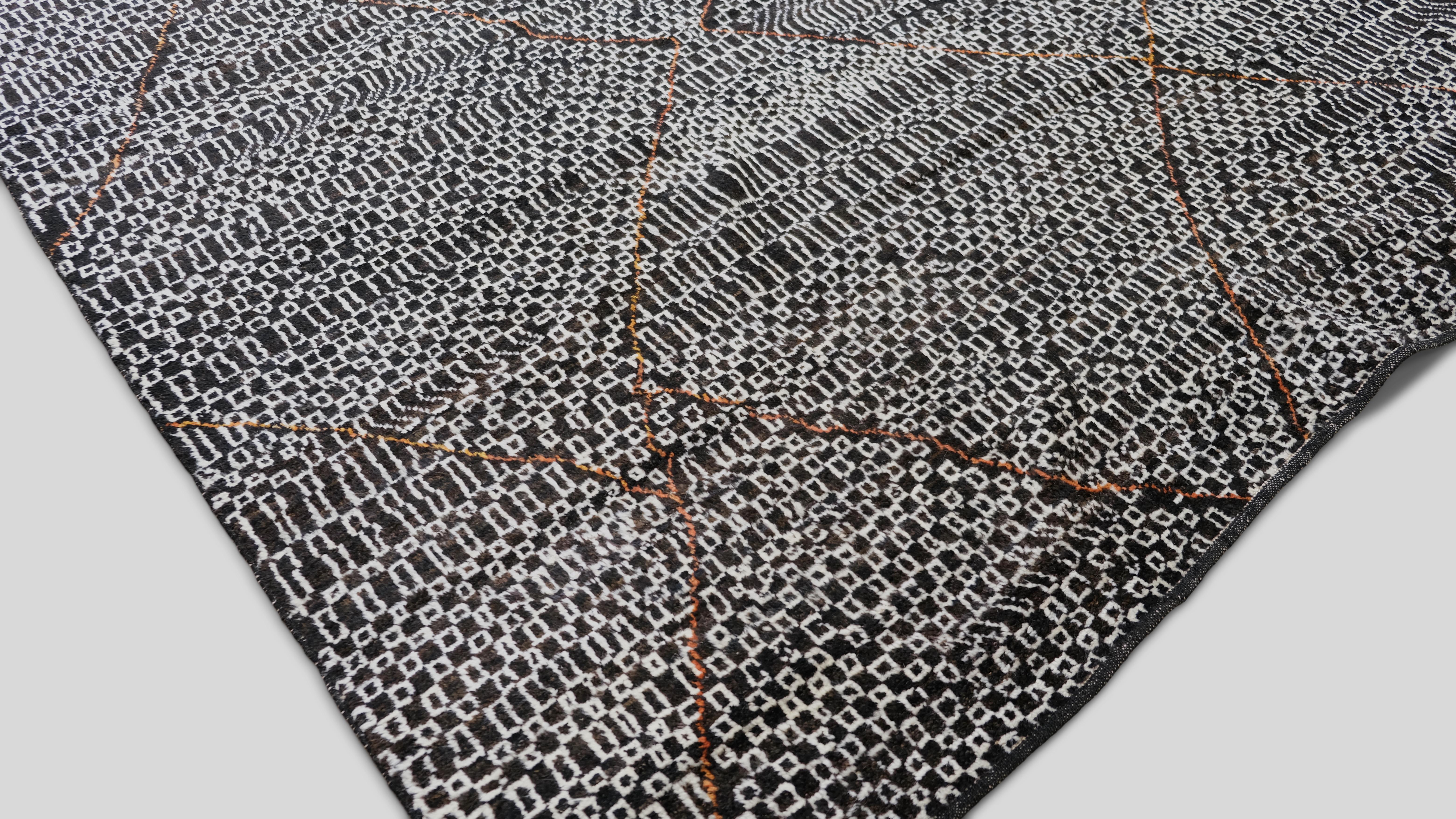 Ajoutez une déclaration audacieuse à votre intérieur avec ce tapis moderne en laine nouée à la main, doté d'un captivant motif de grille abstrait noir et blanc mis en valeur par de subtils accents rouille. Ce design unique allie l'artisanat