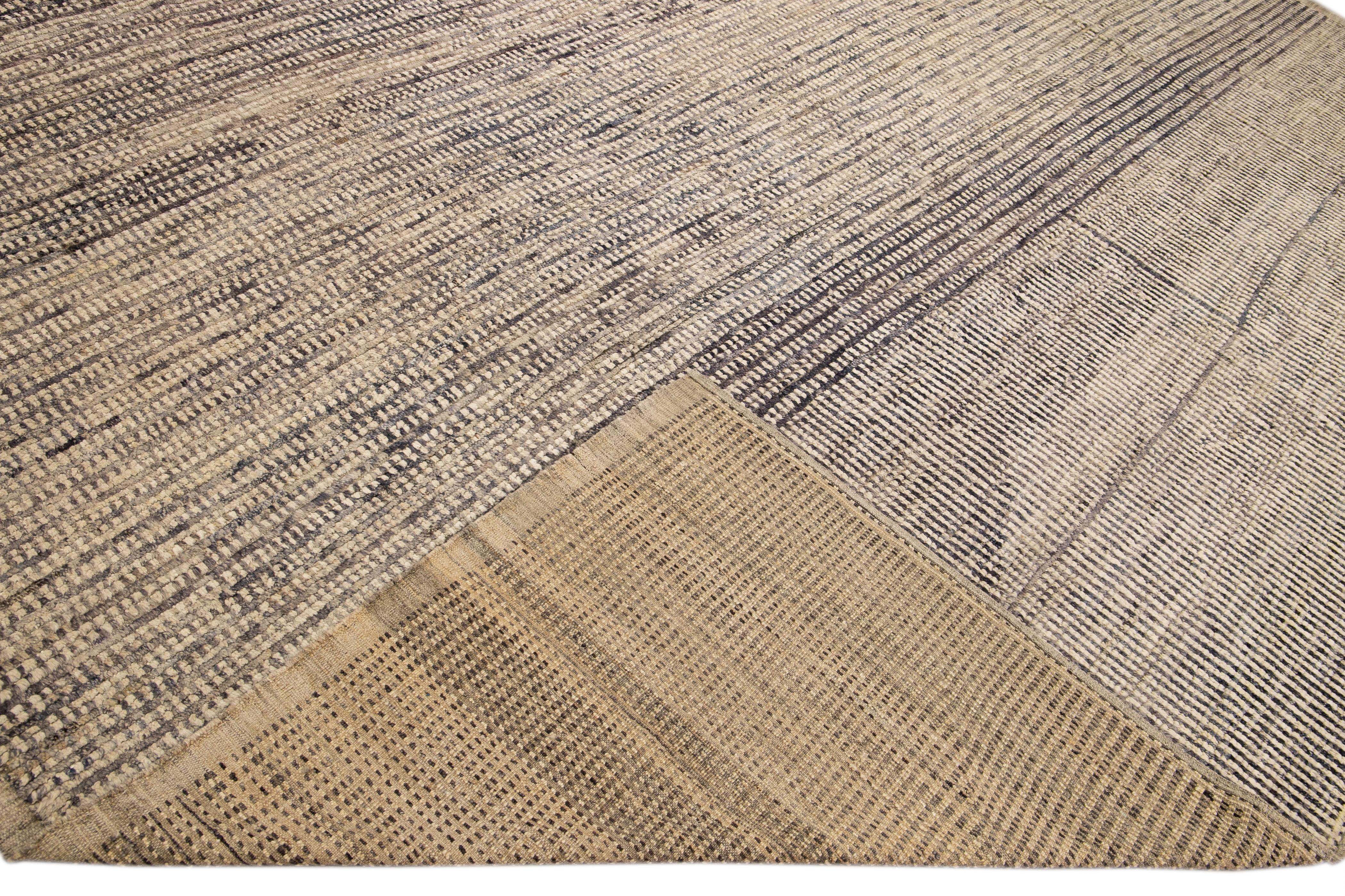 Magnifique tapis en laine fait main de style marocain avec un champ beige. Ce tapis moderne aux accents bruns présente un magnifique motif géométrique bohème sur toute sa surface.

Ce tapis mesure : 13' x 13'1