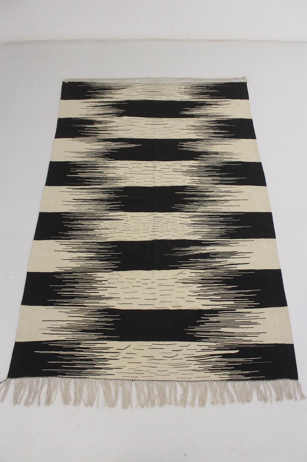 I sourced this newly-made, striped Akhnif in the area of Taznakht, Morocco.

Love the modern pattern and the multiple small lines in the beige parts, that give rhythm to the rug. Colors are beige and black.

This rug is made of wool on a cotton