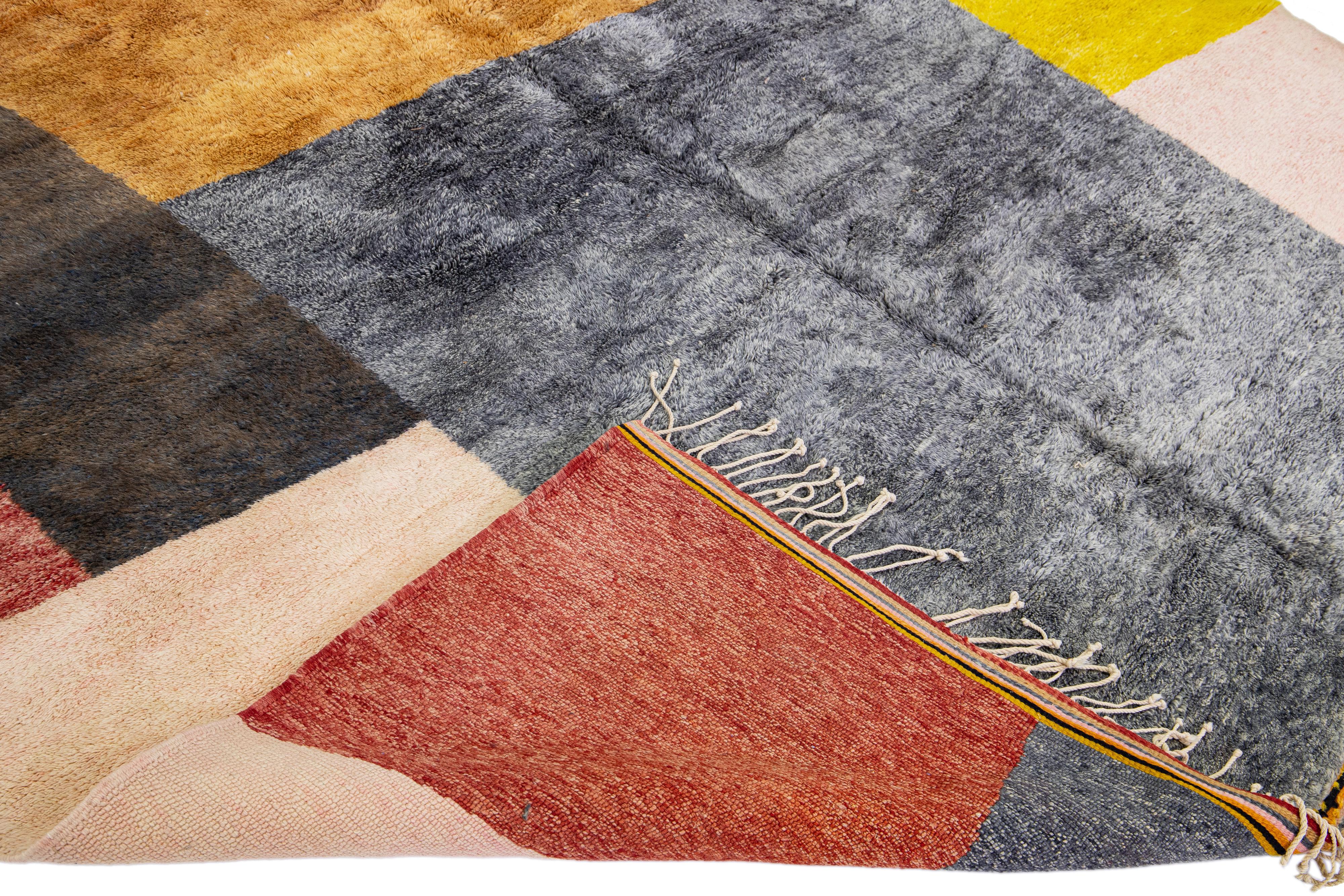 Magnifique tapis marocain en laine noué à la main avec un champ multicolore. Ce tapis moderne présente un magnifique motif géométrique abstrait et des franges beiges.

Ce tapis mesure : 10'8