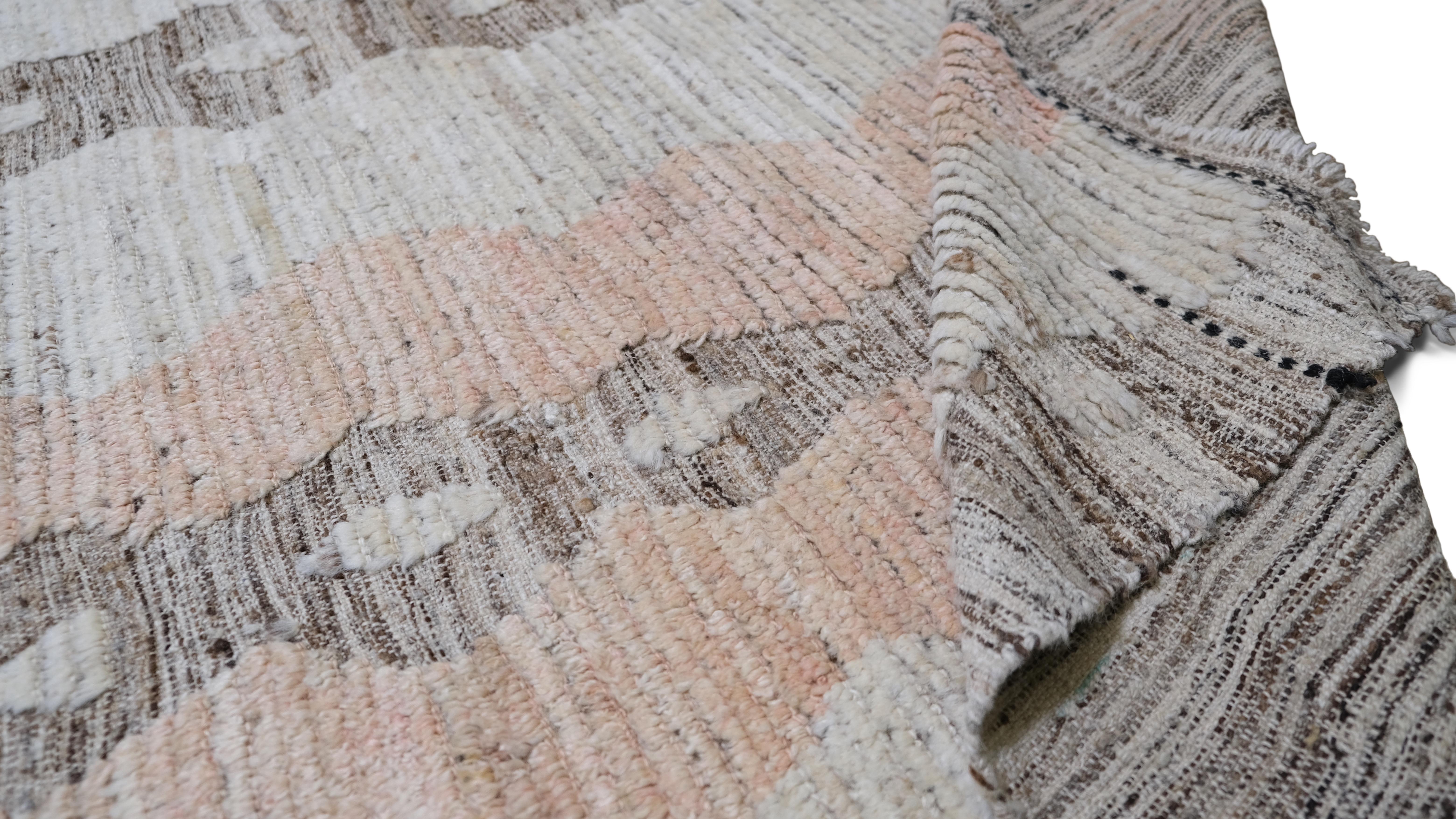 Infuse your space with the soft elegance of this hand-knotted wool rug. Featuring a modern geometric stripe pattern in muted salmon, taupe and grey tones, this rug adds a sophisticated and contemporary touch to your decor. The alternating linear