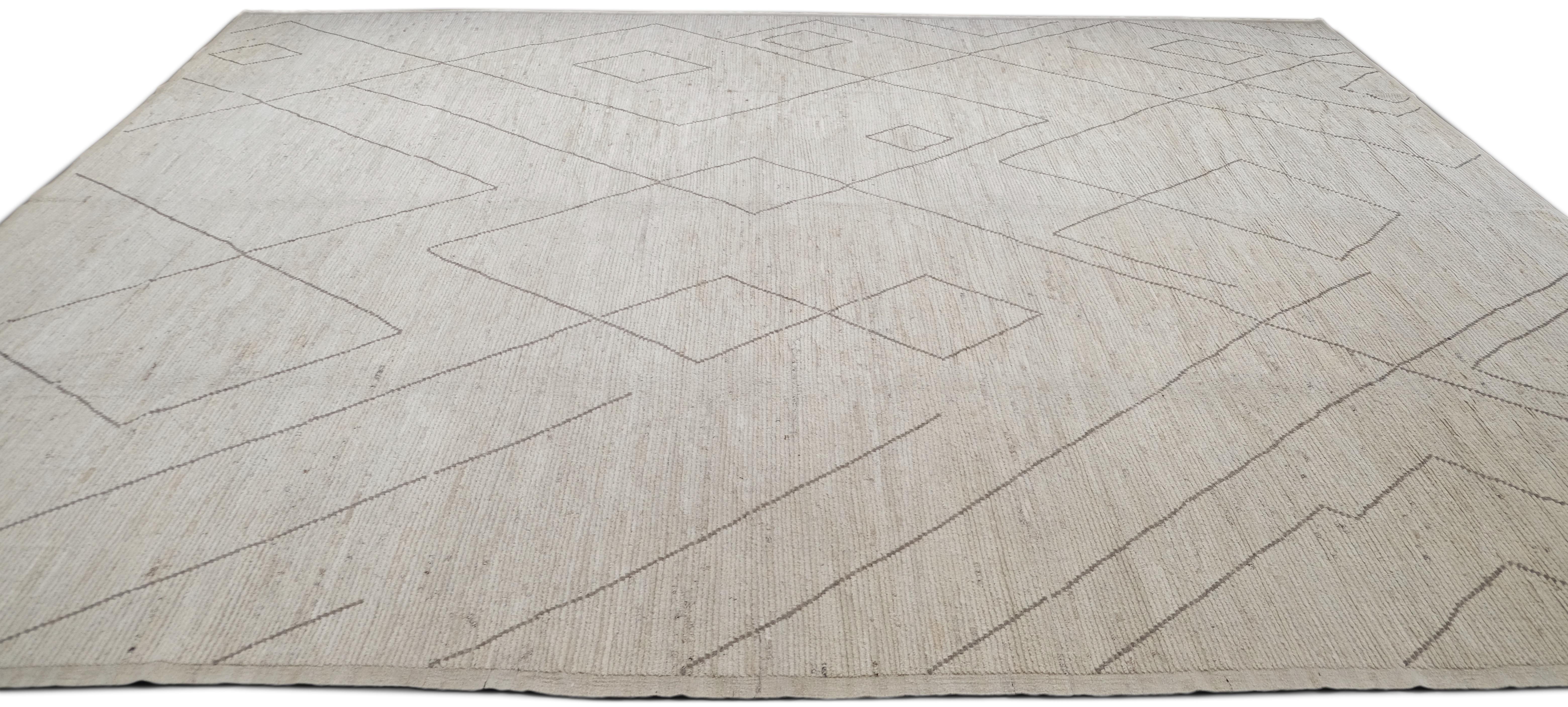 Esta alfombra de lana anudada a mano encarna el minimalismo moderno con su diseño limpio y geométrico. La alfombra presenta un fondo en tono marfil acentuado por motivos lineales abstractos en forma de diamante en un suave color topo que contrasta,