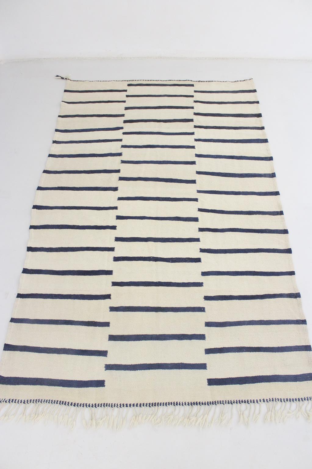I sourced this newly-made, striped kilim Zanafi in the area of Khenifra, Morocco.

Love the modern, minimalist striped pattern and the different shades of navy blue in this one, that reminds me of the coast. The background of the rug is a light