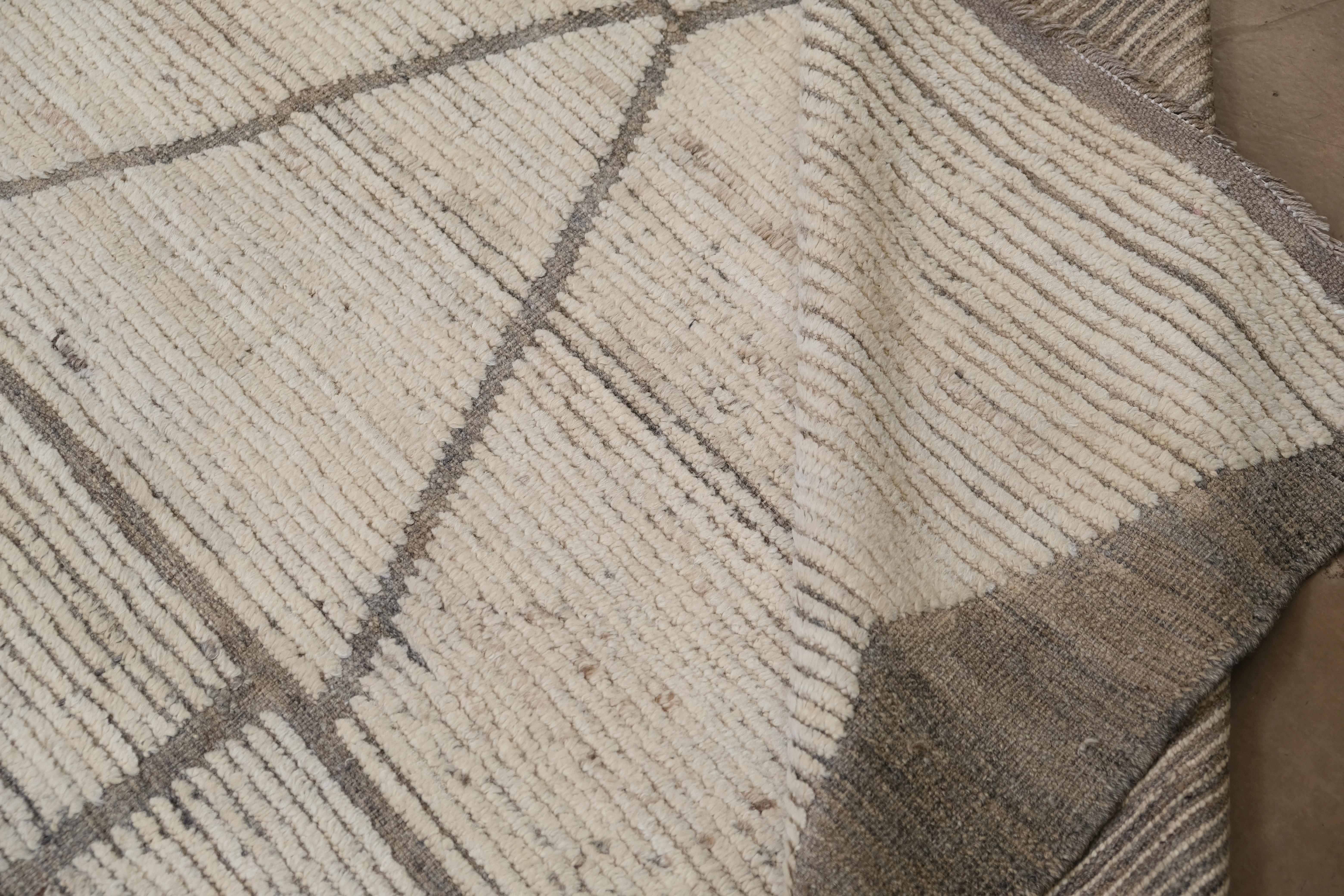 Ce magnifique tapis en laine noué à la main présente un audacieux motif géométrique en chevron qui allie magistralement l'élégance contemporaine à l'art traditionnel. Mesurant approximativement 15' x 23', ce tapis présente des motifs nets et